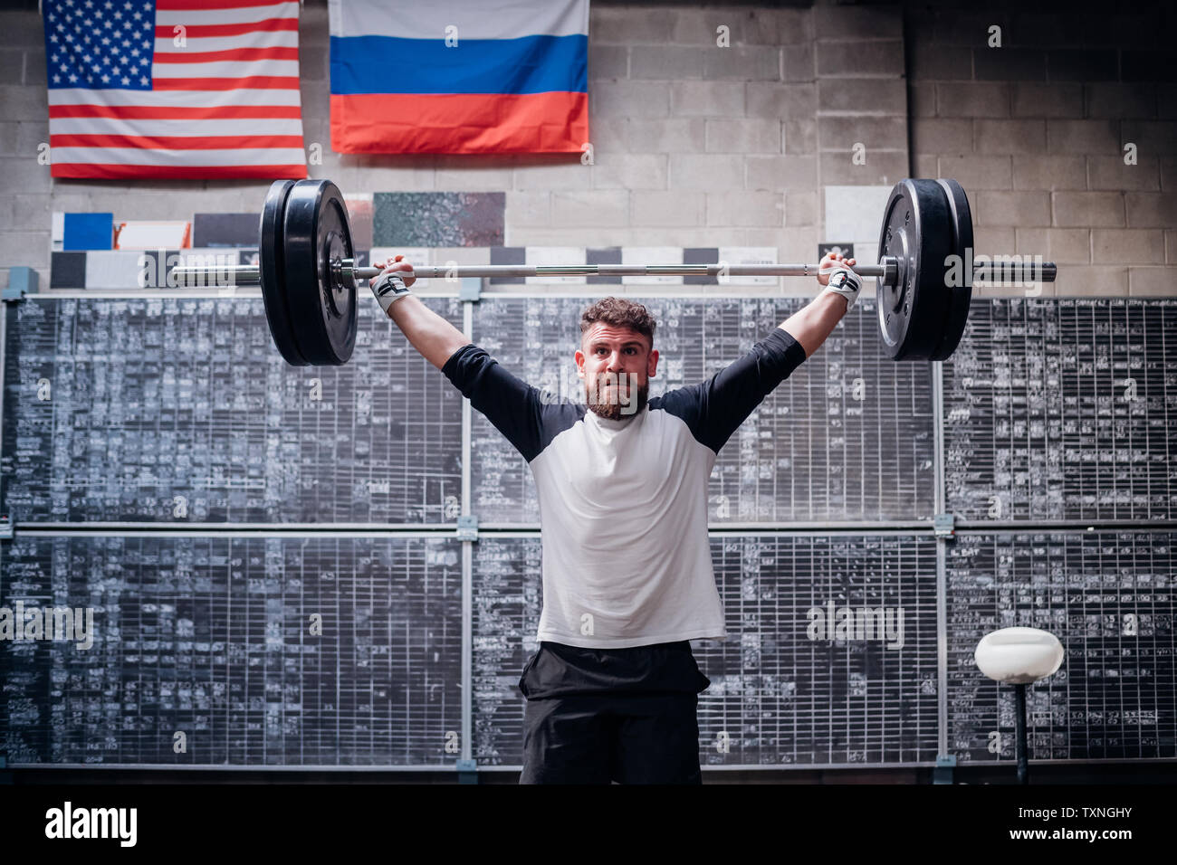 Junger Mann heben Langhantel im Fitness-Studio Stockfoto