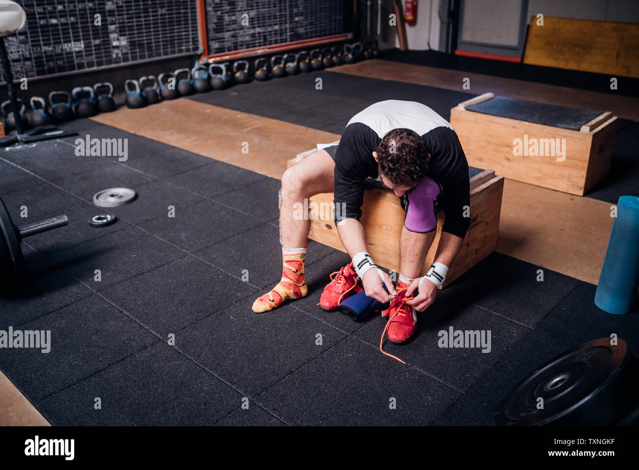 Mann binden Schuhbändern in der Turnhalle Stockfoto