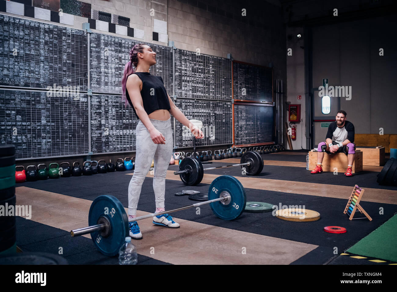 Junger Mann, Frau Vorbereitung barbell in der Turnhalle zu heben Stockfoto