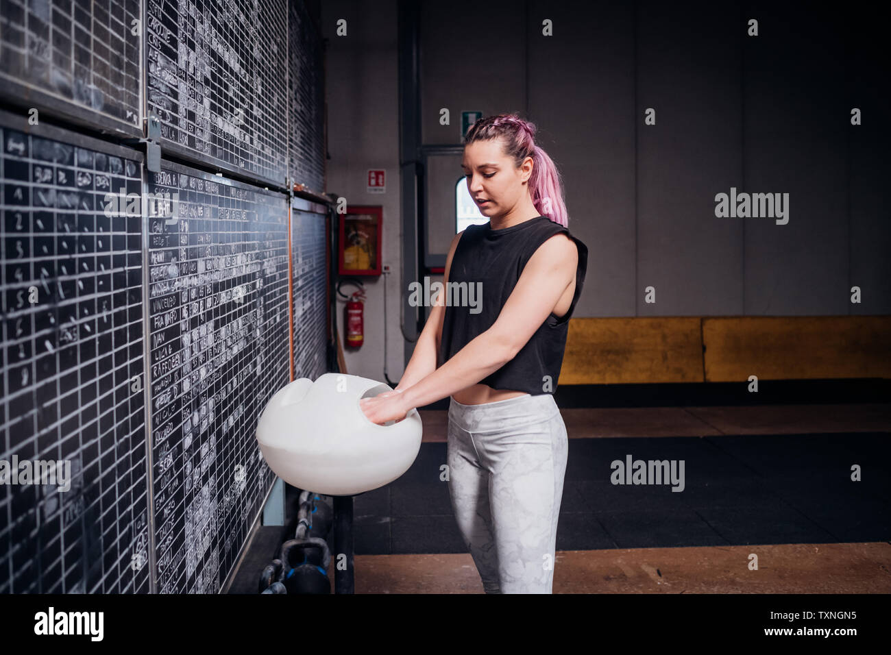 Junge Frau pudern Palmen in der Turnhalle Stockfoto