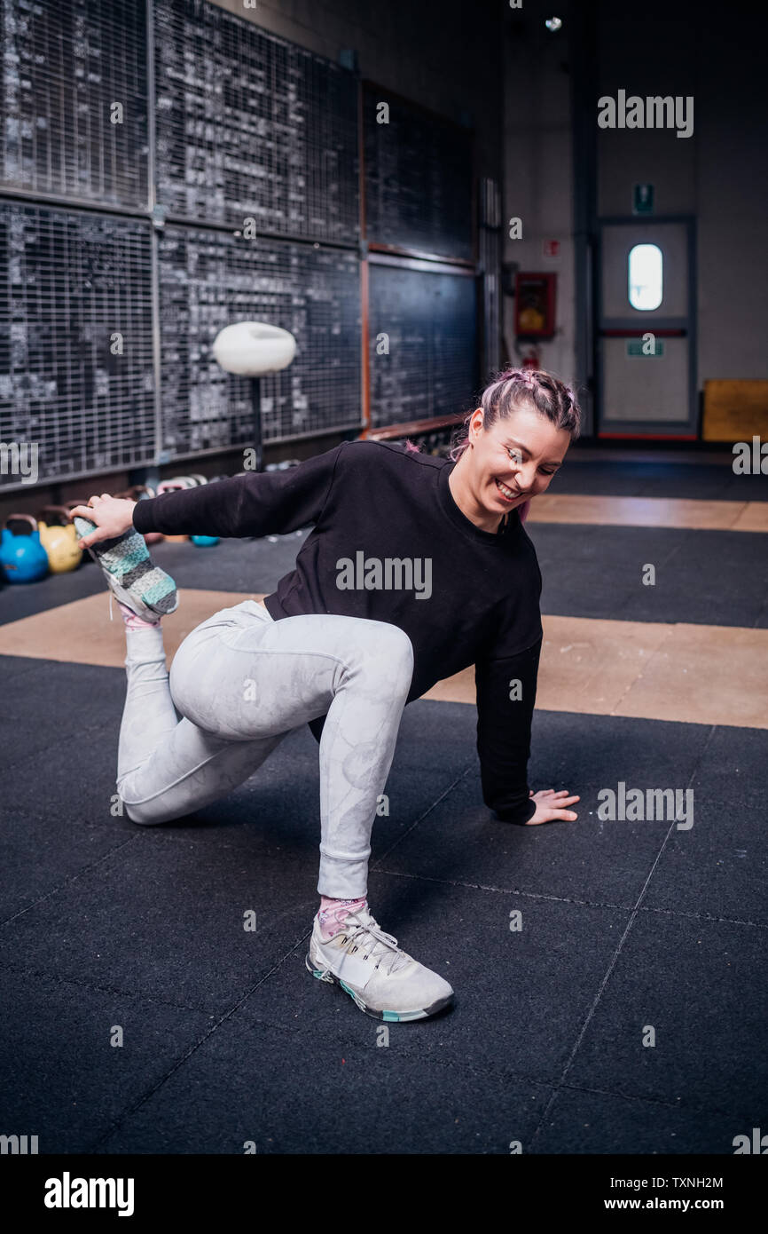 Junge Frau stretching Beine in der Turnhalle Stockfoto