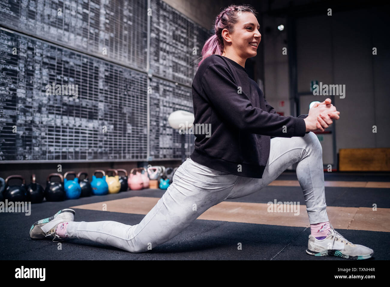 Junge Frau stretching Beine in der Turnhalle Stockfoto
