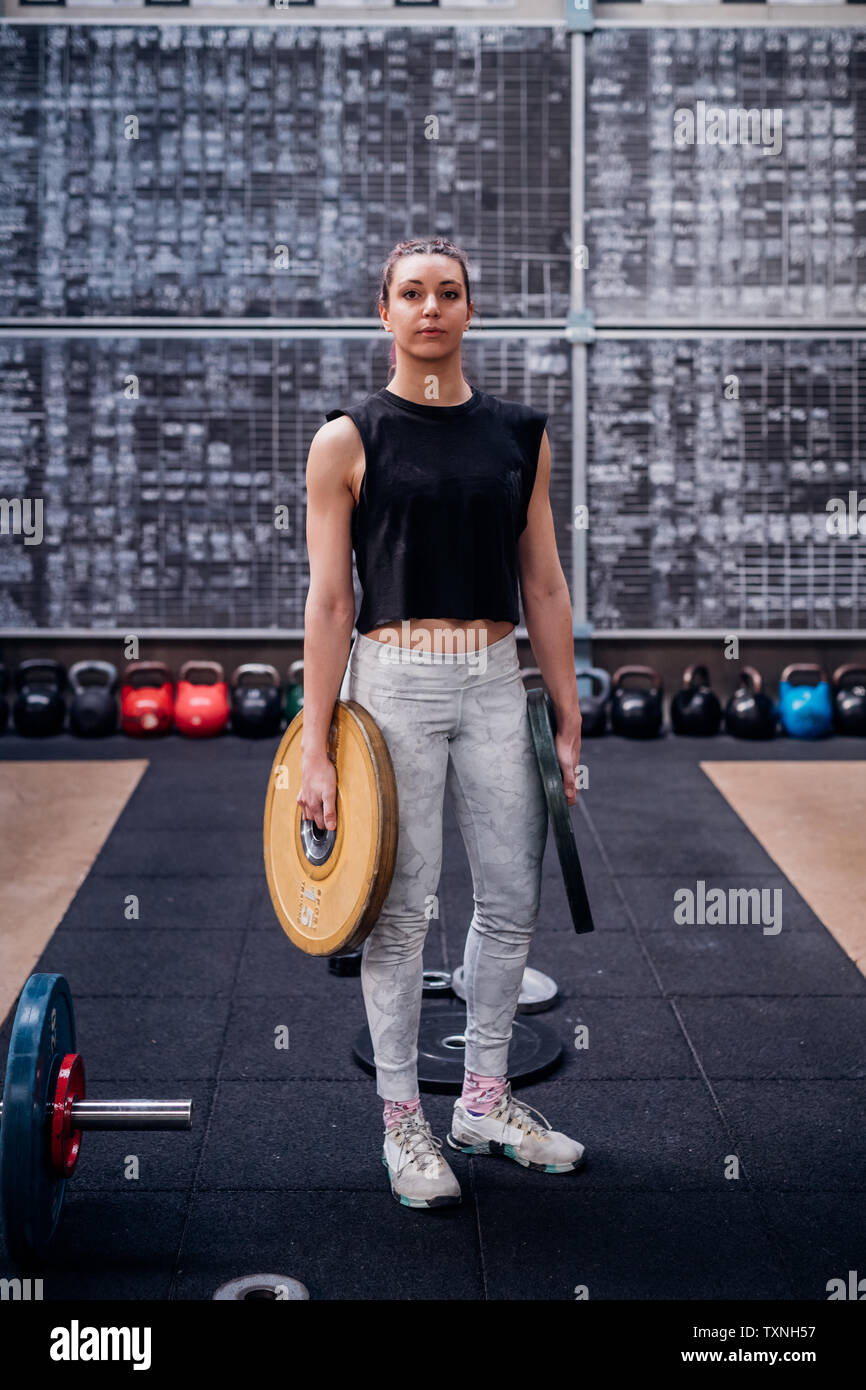 Junge Frau, Gewicht, die Platten in der Turnhalle Stockfoto