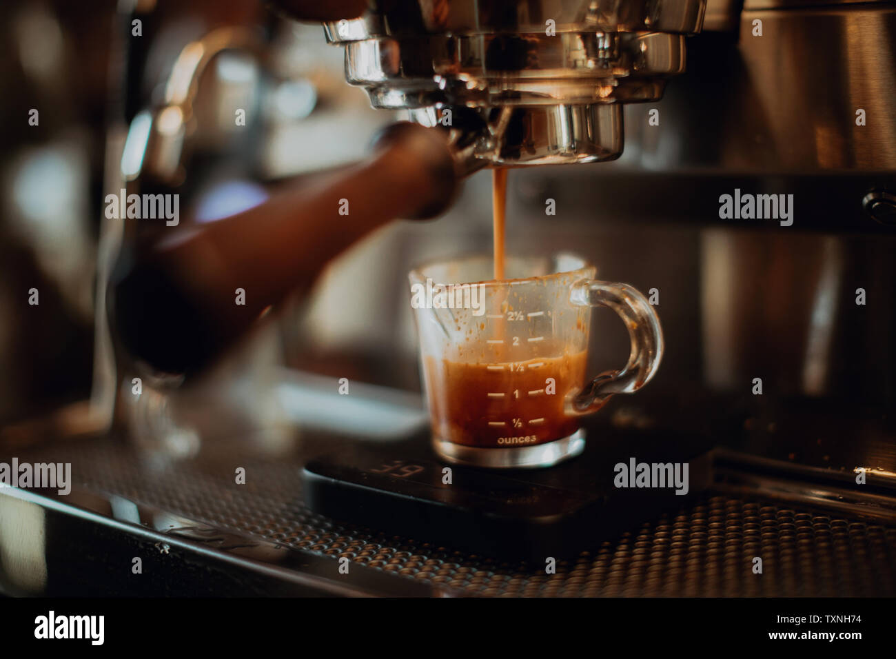 Barista gießen frischen Kaffee in der Kanne auf Kaffeemaschine im Cafe, flacher Fokus Stockfoto