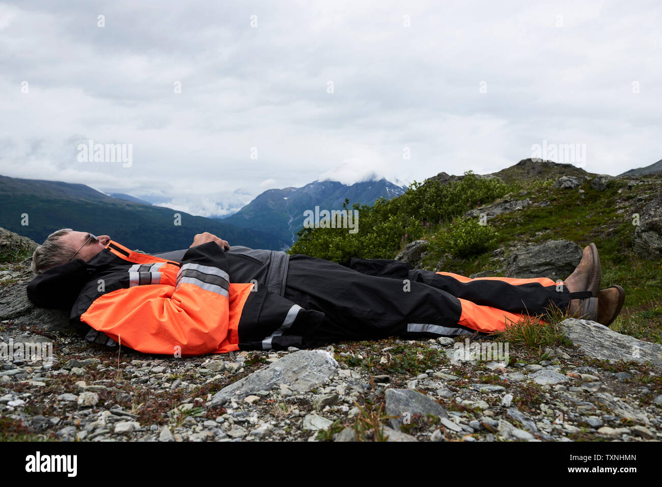 Ältere männliche Wanderer eine Pause liegen oben auf Berg, Seitenansicht, Valdez, Alaska, USA Stockfoto
