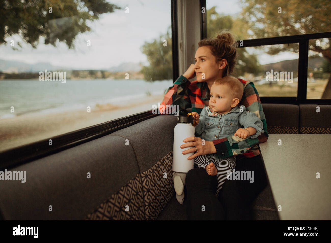 Mutter und Kind suchen Fenster der Reisemobil, Wanaka, Taranaki, Neuseeland Stockfoto