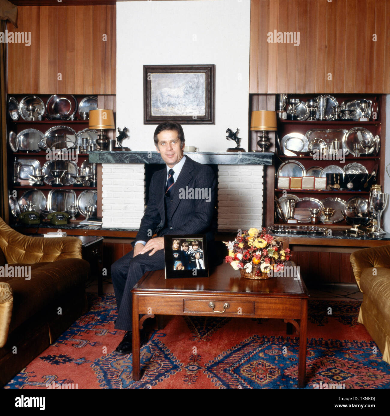 Homestory mit dem ehemaligen deutschen Springreiter Alwin Schockemöhle hier im Wohnzimmer vor-Trophäen, Deutschland Ca. 1980. Mit dem ehemaligen deutschen Springreiter Alwin Schockemöhle hier Homestory im Wohnzimmer vor seiner Trophäen, Deutschland Ca. 1980. Stockfoto