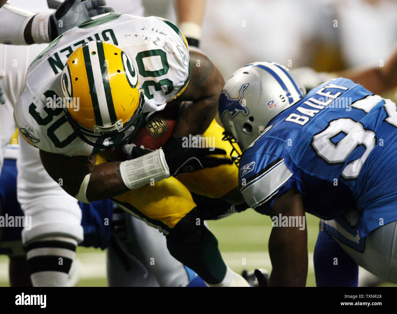 Green Bay Packers Ahman Green zurück laufen (30) bekommt von Detroit Lions Linebacker Chef Bailey (97), als er den Ball in der End Zone läuft für einen Touchdown gegen die Detroit Lions im vierten Quartal im Ford Field in Detroit am 24. September 2006. Die Verpacker besiegten die Löwen 31-24. (UPI Foto/Scott R. Galvin) Stockfoto