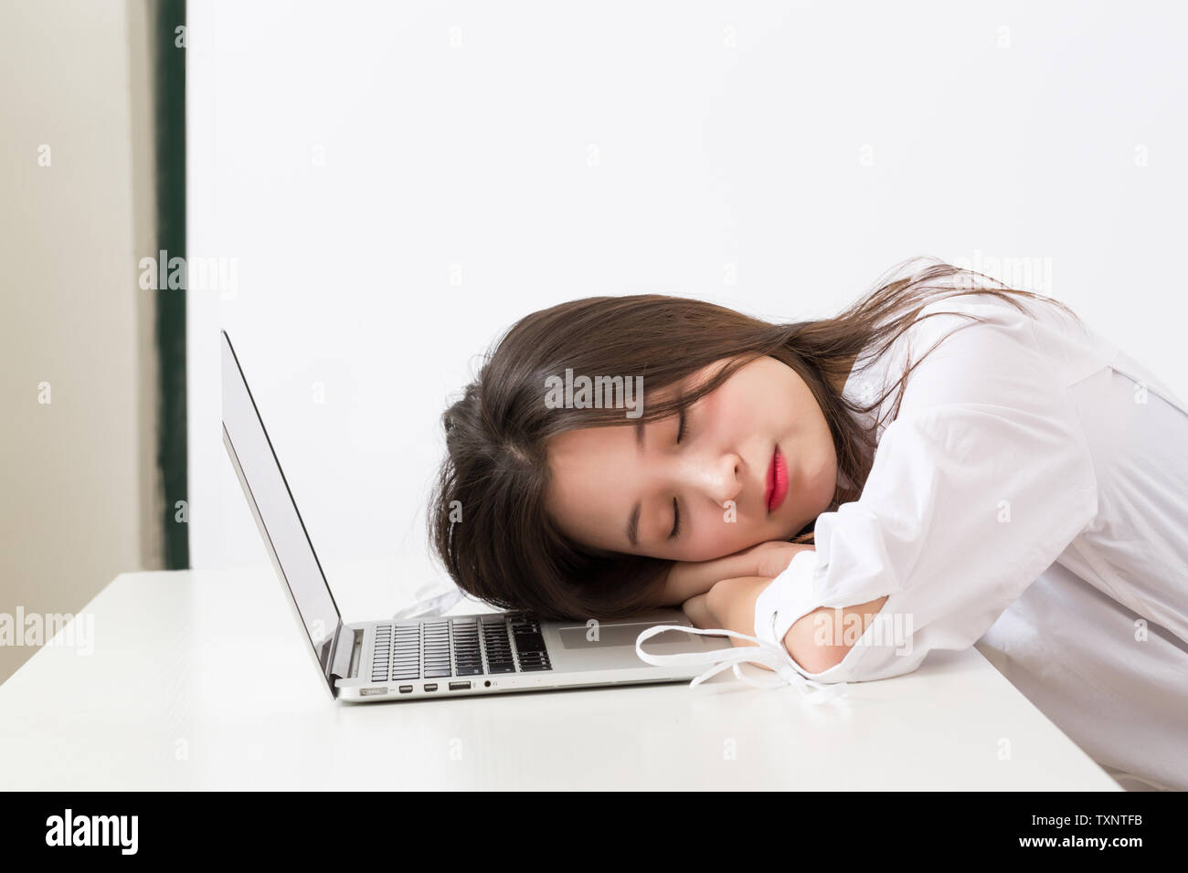 Weibliche Angestellte liegen auf dem Computer. Stockfoto
