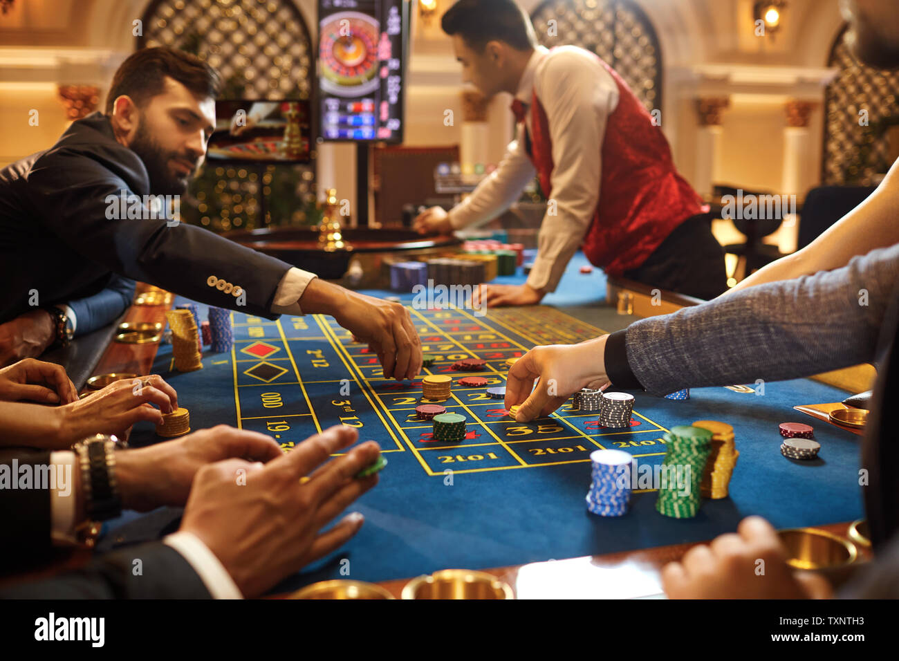 Eine Gruppe von Leuten, die Spieler spielen Glücksspiel Poker Roulette in einem Casino. Stockfoto