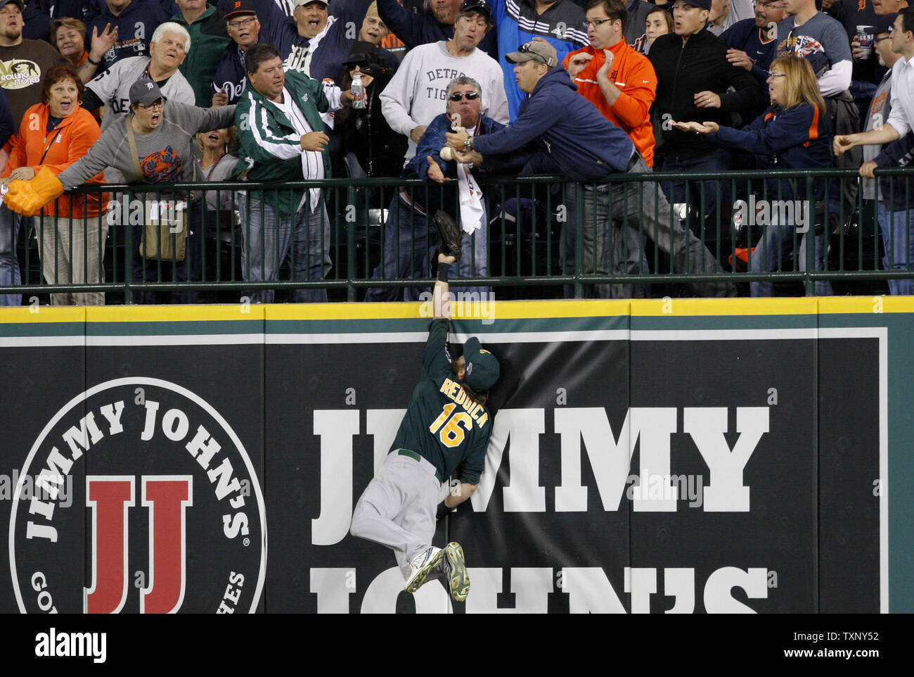 Oakland Athletics rechts Feldspieler Josh Reddick und ein Ventilator erreichen für das solo home run Ball von Detroit Tiger Victor Martinez während des siebten Inning von Spiel 4 der ALDS Spiel bei Comerica Park in Detroit am 8. Oktober 2013. UPI/Rebecca Cook Stockfoto