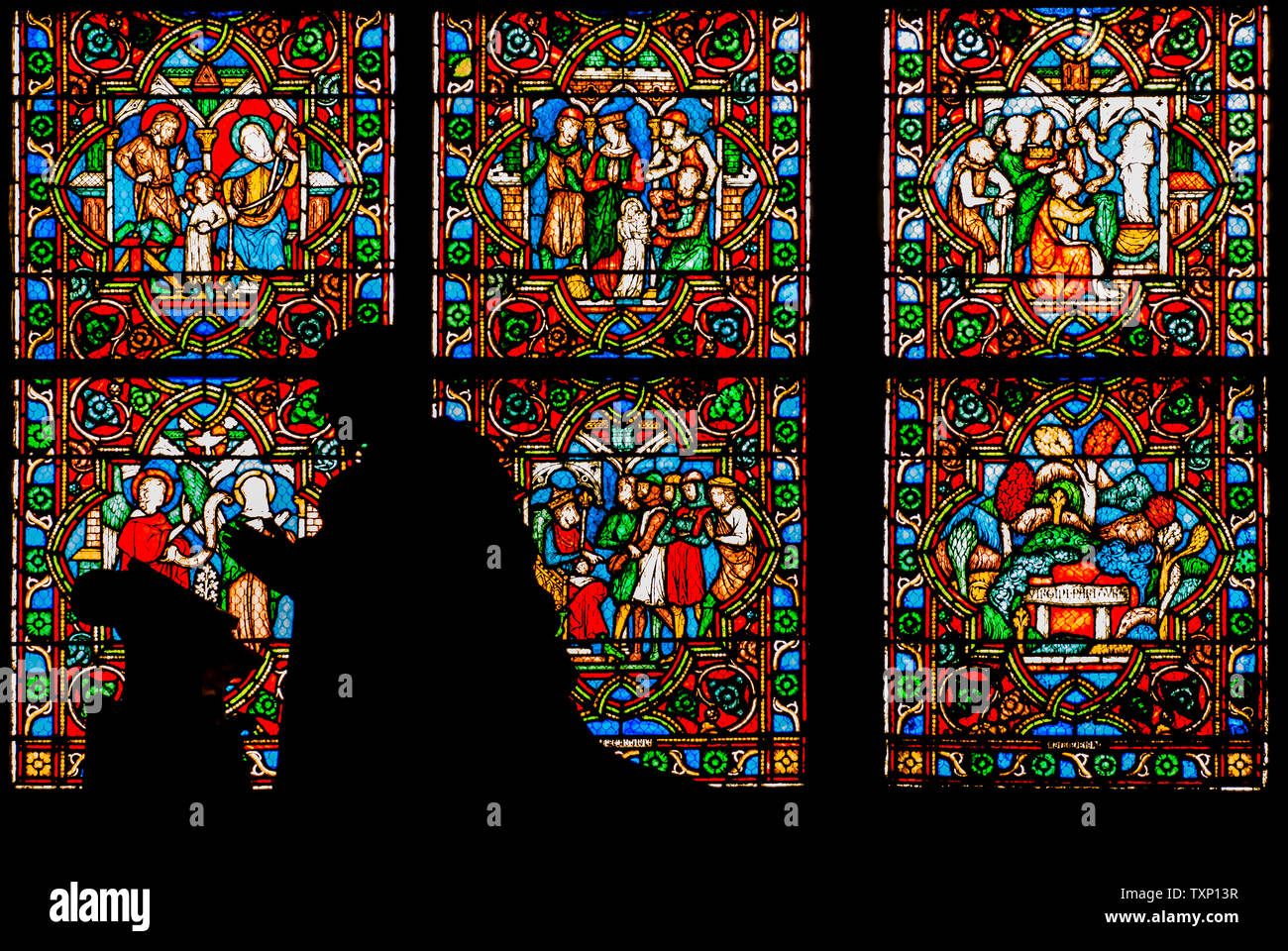 Die ruhe Gebet statue Silhouette mit der getönten Fenster in der Kathedrale von Notre-Dame in Paris. Stockfoto