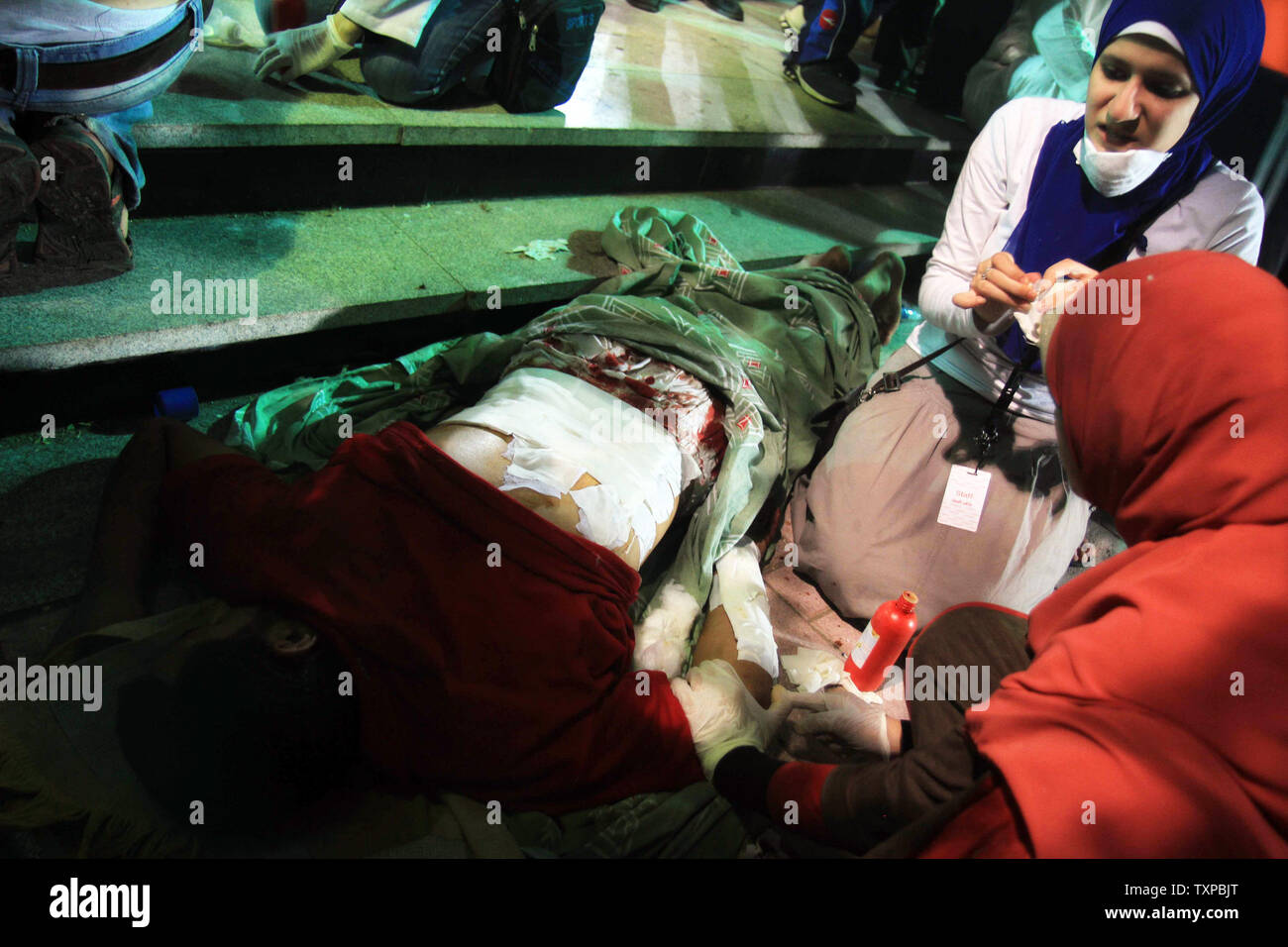 Ärzte behandeln ein Verfechter von Ägyptens gestürzten Präsidenten Mohammed Morsi bei Zusammenstößen mit Sicherheitskräften in Nasr City, wo pro-Mursi Demonstranten gehalten haben eine Wochen verletzt - lange Sit-in, in einem Feld Hospital in Kairo, Ägypten, 27. Juli 2013. Dutzende Menschen haben in der Nacht zu Zusammenstößen zwischen Sicherheitskräften und Anhängern des gestürzten Ägyptischen Präsidenten Mohamed Morsi getötet worden. UPI/Ahmed Jomaa Stockfoto