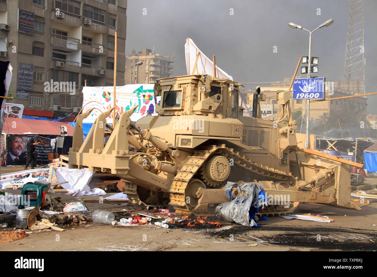 Eine ägyptische Militär bulldozer zerlegt Kairos Al-Nahda square Protest Camp nach ägyptische Sicherheitskräfte Unterstützer von Ägyptens gestürzten Präsidenten Mohamed Morsi in zwei große Lager in der ägyptischen Hauptstadt am 14 August, 2013 verteilt. Sicherheitskräfte ein Vorgehen gegen die Protest Camps, die schnell in ein Blutbad verwandelt mit Dutzenden Toten. Der Ausnahmezustand erklärt wurde. UPI/Karem Ahmed Stockfoto