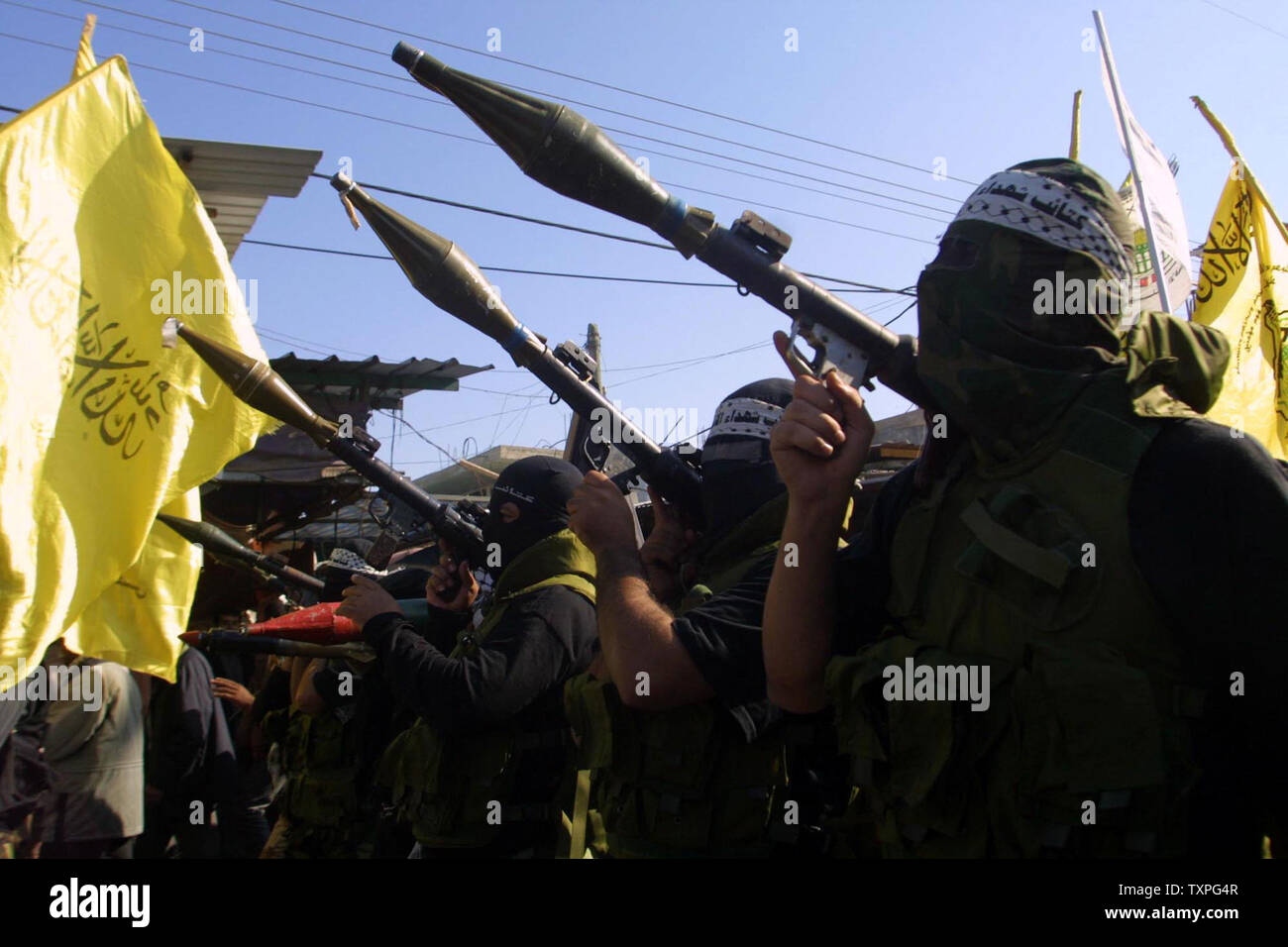 Palästinensischen maskierte Militante aus der Al Aqsa Märtyrer Brigade, eine Gruppe, die der Fatah Bewegung verbunden, live Rakete tragen Granatwerfer während einer Demonstration gegen das Genfer Abkommen im Flüchtlingslager Rafah, im südlichen Gazastreifen, Sonntag, 7. Dezember 2003. Mit palästinensischen Fraktionen, die auf eine komplette End-to-Angriffe gegen Israelis zu vereinbaren. (UPI Foto/Ismael Mohamad) Stockfoto