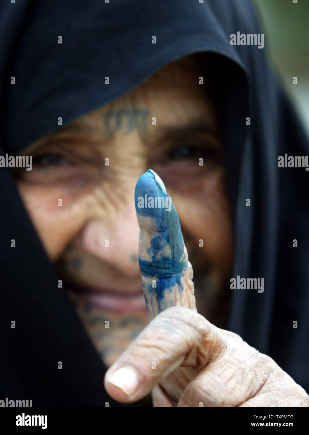 Eine palästinensische Frau zeigt mit dem Finger gebeizt mit unauslöschbarer Tinte, nachdem sie ihre Stimmen in den palästinensischen Wahlen zu einem Wahllokal in Rafah im Gazastreifen Am 25. Januar 2006 abgeben. Umfragen in der West Bank und im Gazastreifen in der nur zweite Wahl in den Gazastreifen eröffnet - auf der Grundlage des Europäischen Parlaments seit der Gründung der Palästinensischen Autonomiebehörde. Die Umfrage wird Siehe die regierende Fatah faction der erste große Test seinen Einfluß auf die radikal-islamische Bewegung Hamas. (UPI Foto/Ismael Mohamad) Stockfoto