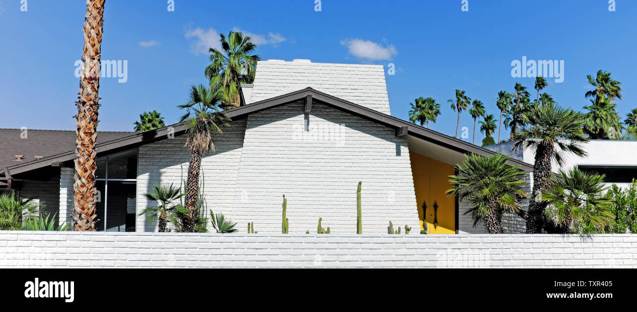 Modernes Designhaus aus dem mittleren Jahrhundert mit einem Dach, gelben Türen, Palmen und Wüstenflora in Palm Springs, Calfornia, Ohio, USA. Stockfoto