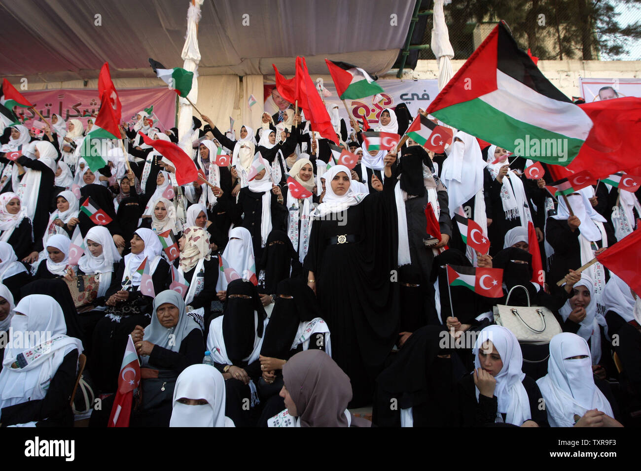 Palästinensischen Bräute wave Palästinensischen und türkische Flaggen während einer Messe Hochzeit in Gaza Stadt, am 31. Mai 2015. Fast 2000 palästinensische Paare in einer Zeremonie von der türkischen Regierung finanziert und von der Hamas unterstützte verheiratet waren, palästinensische Beamte. Foto von Ismael Mohamad/UPI Stockfoto