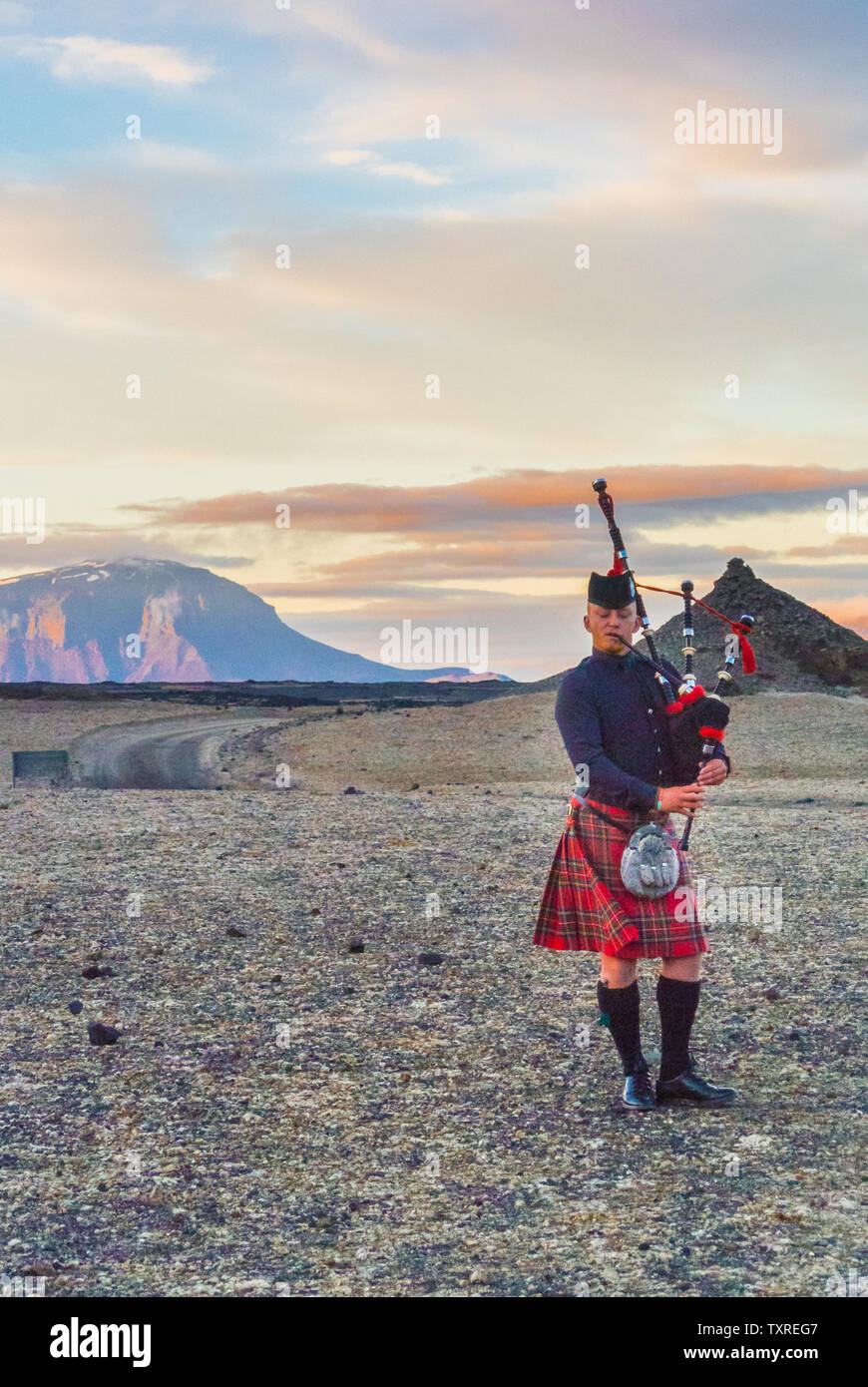 Scottish Piper, Isländisch Wüste. Herdubreid. Herðubreið im Hintergrund. Stockfoto