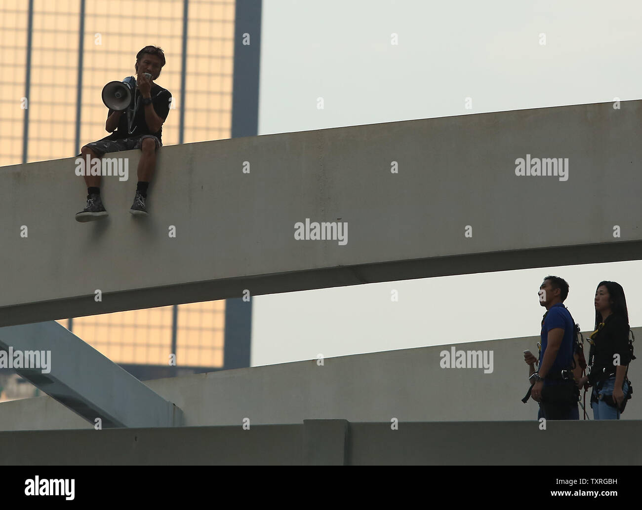 Eine "anti-Hongkong" demonstrant besetzen droht von einer Brücke zu springen, wenn die pro-demokratischen Aktivisten weiter Teile der Innenstadt von Hong Kong am 5. Oktober 2014 zu schließen. Die Demonstranten blieben in einem angespannten Patt mit der Regierung von Hongkong am Sonntag spät nach Behörden gewarnt, sie tun würden, was es nimmt, um die Folgen der Nabe wieder zum Laufen zu bringen, nachdem mehr als eine Woche der Unruhen. UPI/Stephen Rasierer Stockfoto