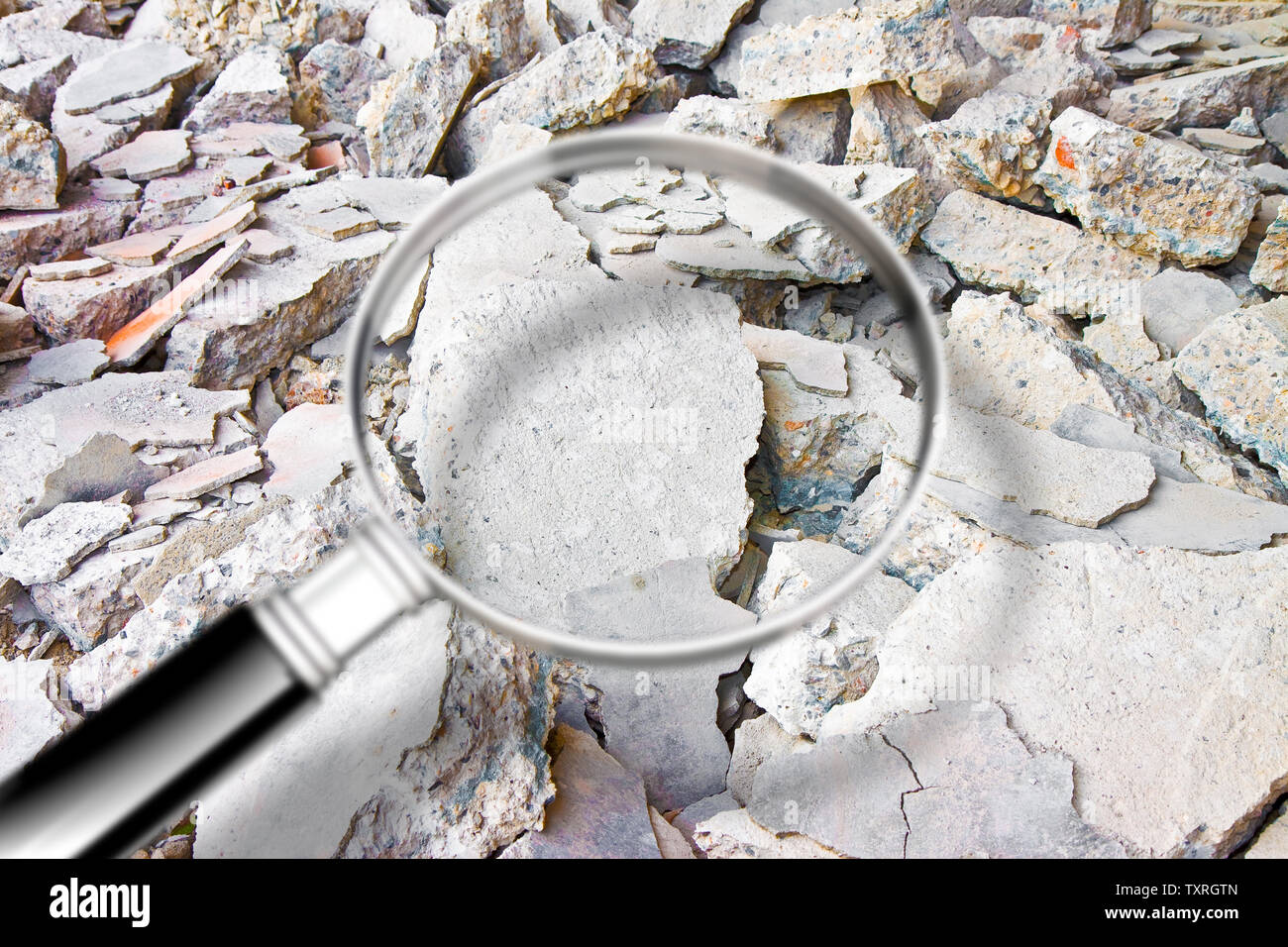 Auf der Suche nach Gefahr durch Asbest Partikel in industriellen Abfällen nach dem Abriss einer Betonwand-Konzept Bild durch ein Vergrößerungsglas gesehen Stockfoto