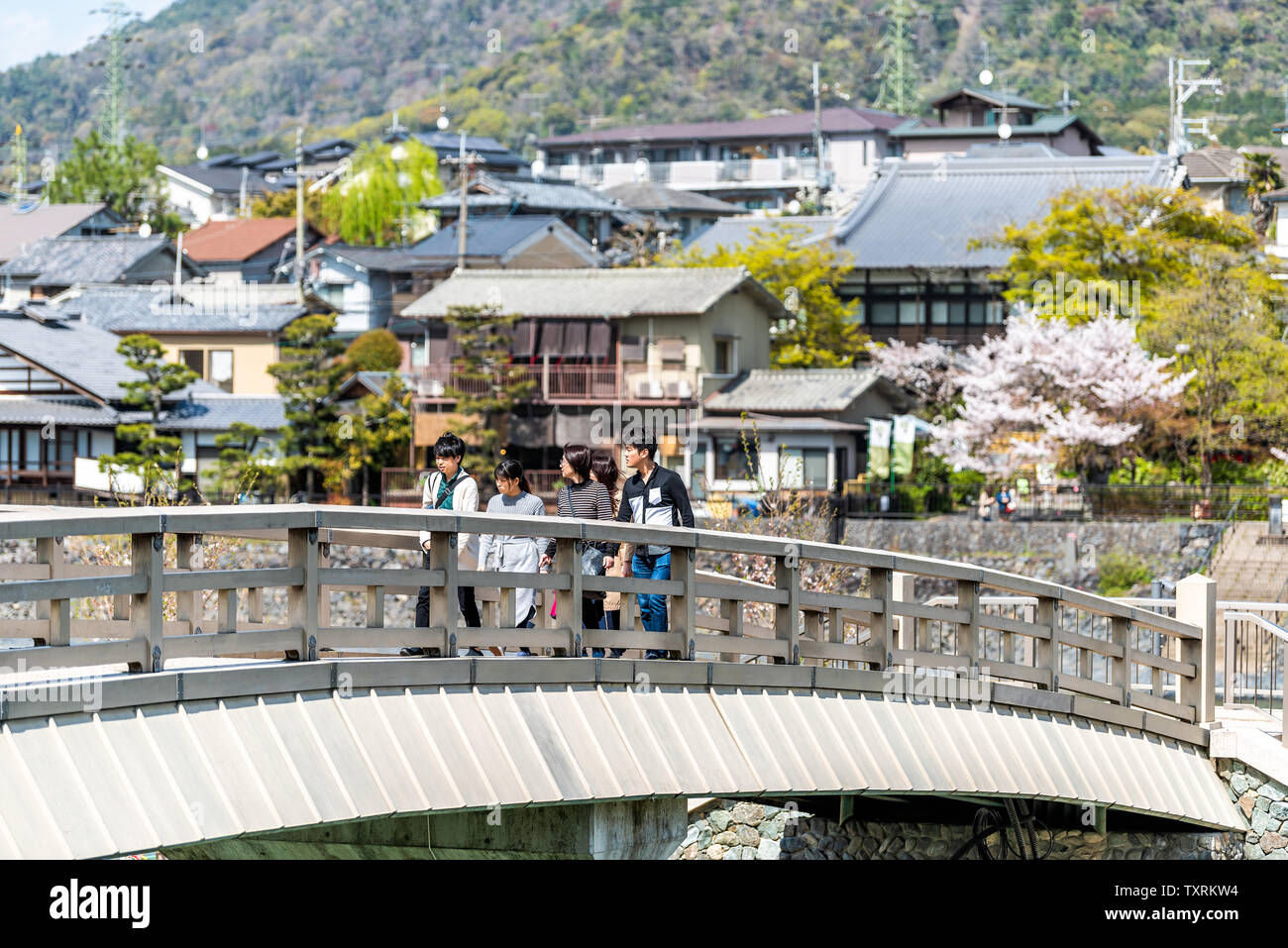 Uji, Japan - 14 April, 2019: Fluss im Frühjahr im traditionellen Dorf mit Blick auf die Häuser Stadtbild und die Menschen zu Fuß über die Brücke und Cherry bl Stockfoto