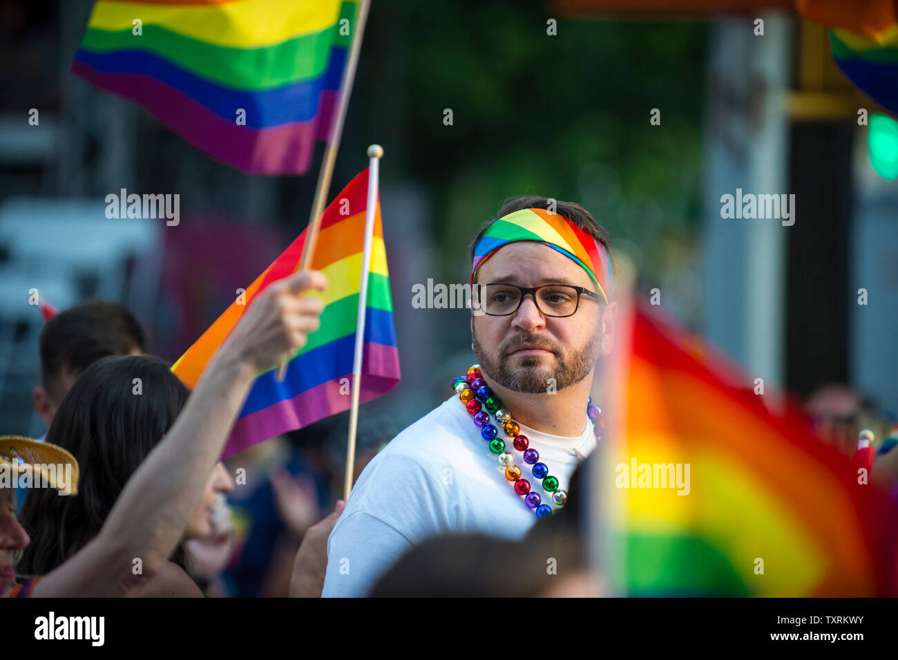 NEW YORK CITY - 25 Juni, 2017: ein Mann mit einem Regenbogen Flagge bandana Spaziergänge in die jährliche Gay Pride Parade, wie es durch Greenwich Village. Stockfoto