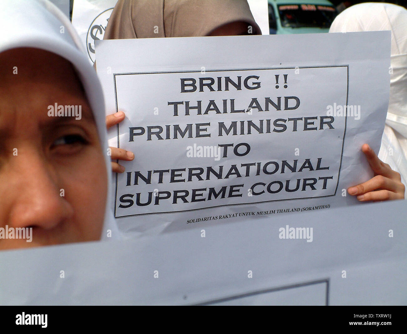 Eine weibliche Demonstrant hält ein Plakat während einer Demonstration vor der Thailändischen Botschaft in Jakarta, 29. Oktober 2000, die seniorenuniversität neue Tod von mindestens 84 muslimischen Aufständischen in der Provinz Narathiwat. Mindestens 200 Demonstranten zeigten ihre religiöse Solidarität und verurteilte die thailändische Polizei Aktion, die auf die große Zahl der Todesopfer geführt. (UPI/Newspictures Saprizal) Stockfoto