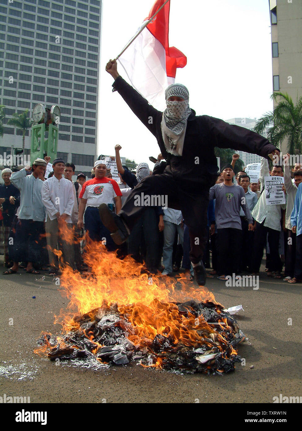 Ein Demonstrant jumpas über dem Lagerfeuer während einer Demonstration vor der Thailändischen Botschaft in Jakarta, 29. Oktober 2000. Mindestens 200 Demonstranten zeigten ihre religiöse Solidarität und verurteilte die thailändische Polizei Aktion, die auf die große Zahl der Todesopfer von 84 muslimischen Aufständischen in der Provinz Narathiwat led in Südthailand. (UPI/Newspictures Saprizal) Stockfoto