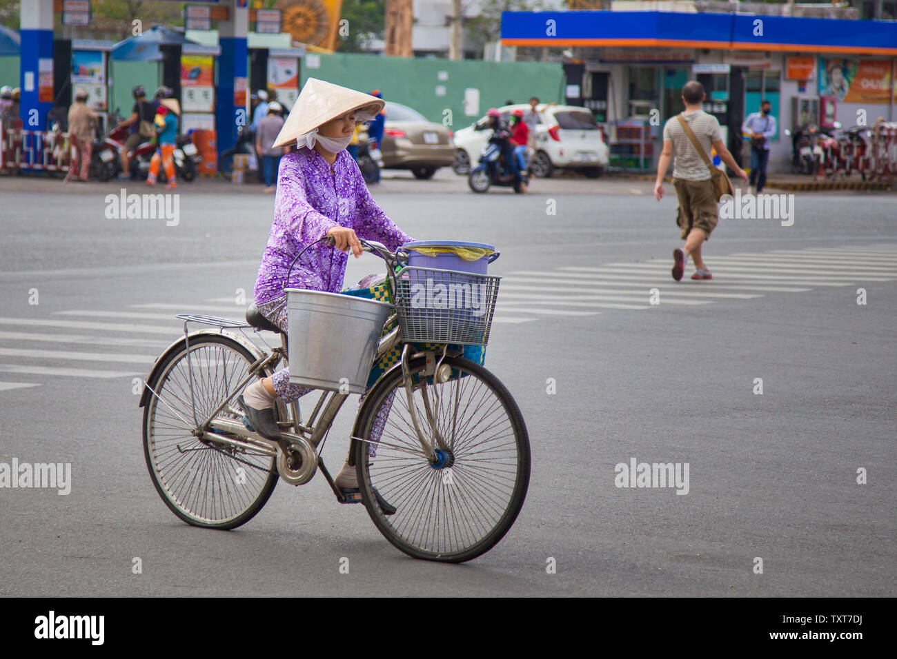Ho Chi Minh City, Vietnam - Dezember 14, 2013: Einsame Frau Reiten Fahrrad tragen typische Kleidung auf einer Straße von Ho Chi Minh City Stockfoto