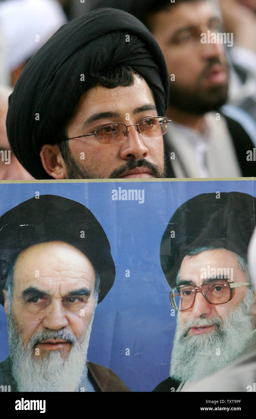 Ein Iranischer Kleriker hält eine Abbildung des Obersten Führers des Iran, Ajatollah Ali Khamenei (R) und der Gründer der Islamischen Revolution Ayatollah Ruhollah Khomeini (L) an seinem Mausoleum südlich von Teheran während einer Feier zum 16. Jahrestag seines Todes Juni 4, 2005. Khomeini, ein religiöser Führer, der aus dem Exil 1979 beliebte Revolution, die die Herrschaft des Schah von Iran gestürzt führte, starb 1989 an Krebs. Irans Oberster Führer Ayatollah Ali Khamenei rief zu einer hohen Wahlbeteiligung bei den Präsidentschaftswahlen am 17. Juni Umfragen als Zeichen der anhaltenden Unterstützung für klerikalen Establishment des Landes. (UPI Stockfoto