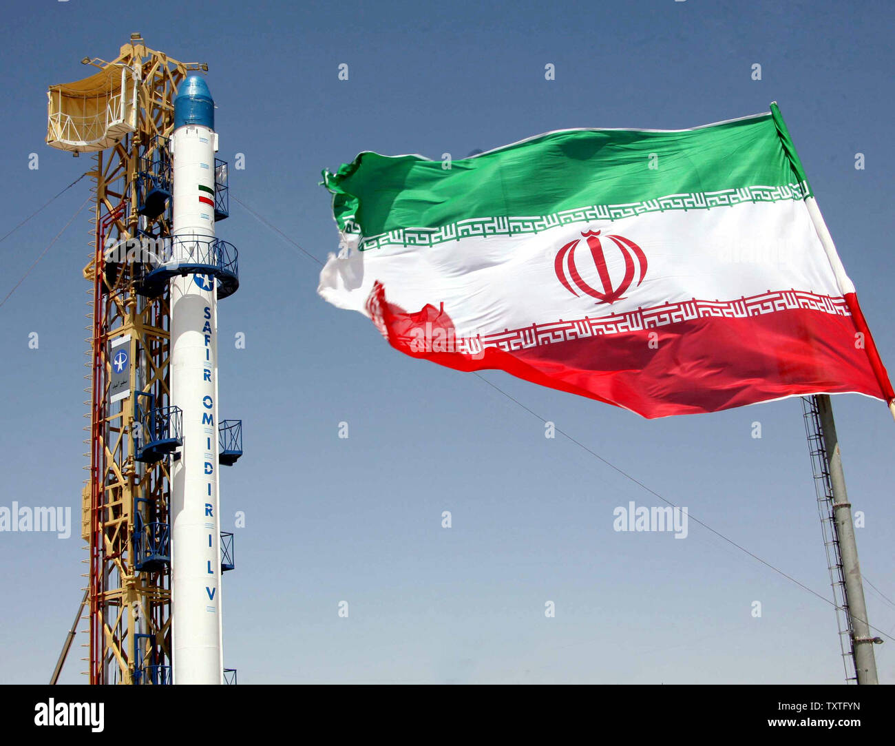 Irans Safir-e Omid (Botschafter der Hoffnung) Rakete, die fähig ist, einen Satelliten in eine Umlaufbahn befindet sich neben dem Iran Flagge vor dem Start an der Iran Space Center in Teheran, Iran, am 17. August 2008. Der Omid Programms ist das erste derartige System vollständig durch iranische Wissenschaftler entwickelt, heißt es in dem Bericht, das Hinzufügen von Wissenschaftler werden fünf weitere Satelliten in den Orbit starten von 2010. (UPI Foto/Fars News Agency) Stockfoto