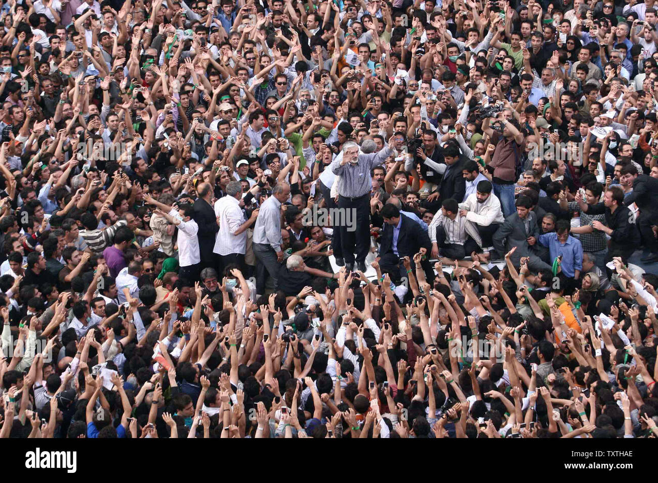 Irans reformistischen Kandidaten Mir Hossein Mussawi (C) Wellen unter seine Anhänger auf den Straßen von Teheran gegen die Ergebnisse der iranischen Präsidentschaftswahl, in Teheran, Iran am 15. Juni 2009 zu demonstrieren. Im März kam Stunden nach Irans Oberster Führer Ayatollah Ali Khamenei eine Prüfung in Wahlbetrug bestellt. (UPI Foto) Stockfoto