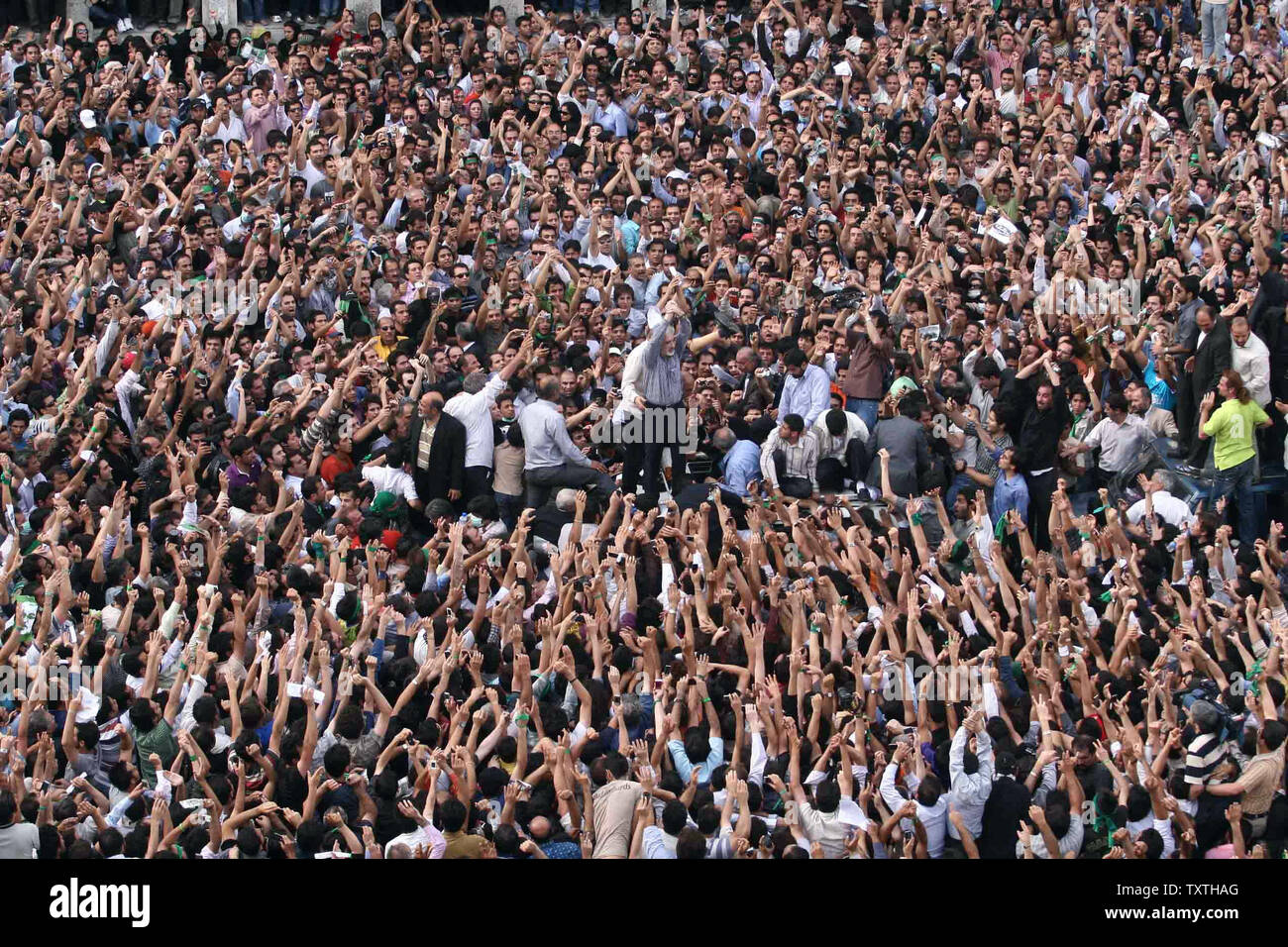 Irans reformistischen Kandidaten Mir Hossein Mussawi (C) Wellen unter seine Anhänger auf den Straßen von Teheran gegen die Ergebnisse der iranischen Präsidentschaftswahl, in Teheran, Iran am 15. Juni 2009 zu demonstrieren. Im März kam Stunden nach Irans Oberster Führer Ayatollah Ali Khamenei eine Prüfung in Wahlbetrug bestellt. (UPI Foto) Stockfoto