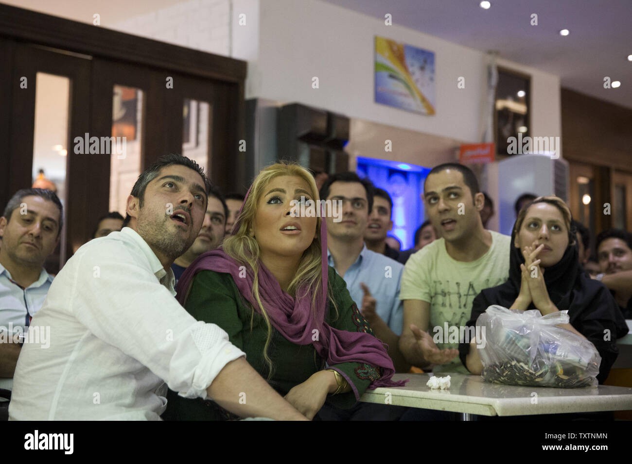 Iranische Fußball-Fans sehen Sie ein WM-Spiel zwischen Iran und Argentinien in einem Restaurant im Norden von Teheran am 21. Juni 2014. Die Polizei hat Teherans Restaurants und Cafés aus, die WM-Spiele verboten, aber die Reihenfolge ist von vielen Cafés und Fußball-Fans ignoriert worden. UPI/Maryam Rahmanian Stockfoto