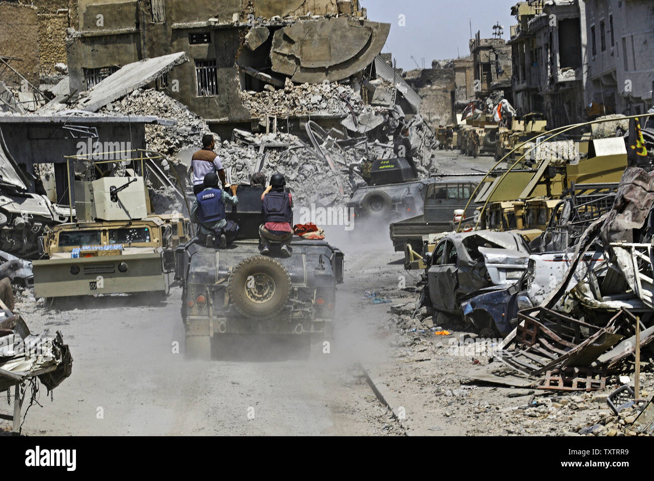 Gebäude abgerissen und Autowracks gesehen nach Mosul war frei von Isis erklärt, in Mossul, Irak am 10. Juli 2017. Irak verkündete einen endgültigen Sieg in den fast neun Monate offensive Mossul von Dschihadisten zu wiederholen, wie Feiern unter der Polizei in der Stadt brach. Foto von Hana Noori/UPI Stockfoto