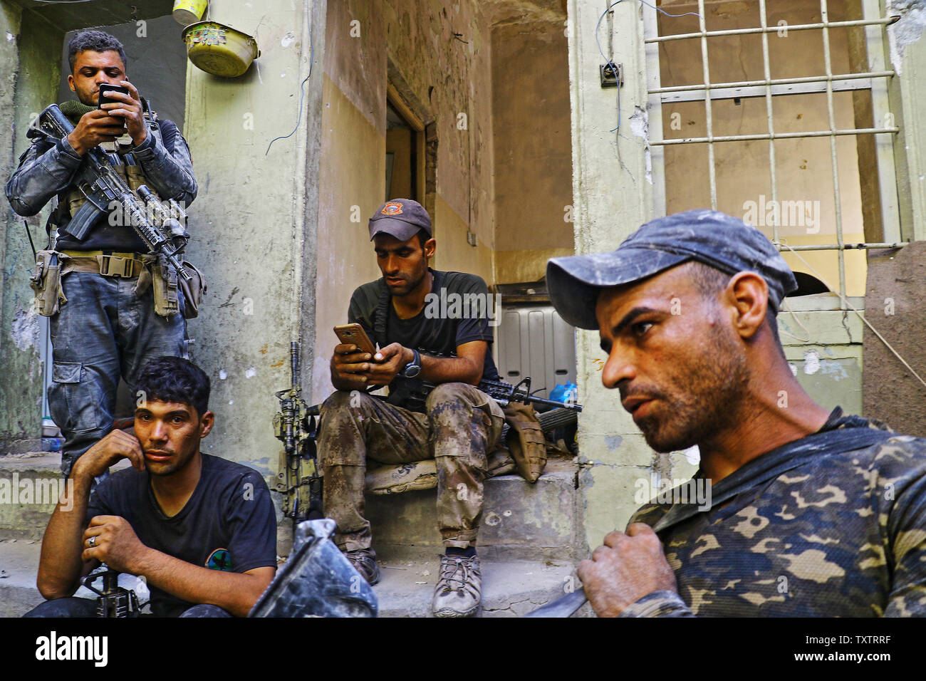 Irakische Soldaten sitzen vor der zerstörten Gebäude in Mossul nach war die Stadt frei von ISIS, in Mossul, Irak am 10. Juli 2017 erklärt. Irak verkündete einen endgültigen Sieg in den fast neun Monate offensive Mossul von Dschihadisten zu wiederholen, wie Feiern unter der Polizei in der Stadt brach. Foto von Hana Noori/UPI Stockfoto