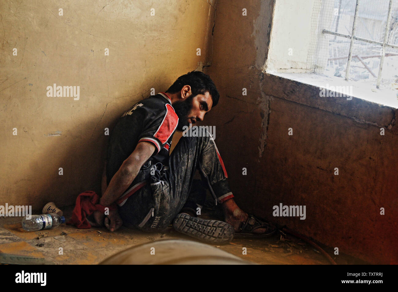 Ein vermuteter Islamischen Staat Fighter sitzt in einem Keller in der alten Stadt von Mosul, Irak, 10. Juli 2017. Irak verkündete einen endgültigen Sieg in den fast neun Monate offensive Mossul von Dschihadisten zu wiederholen, wie Feiern unter der Polizei in der Stadt brach. Foto von Hana Noori/UPI Stockfoto