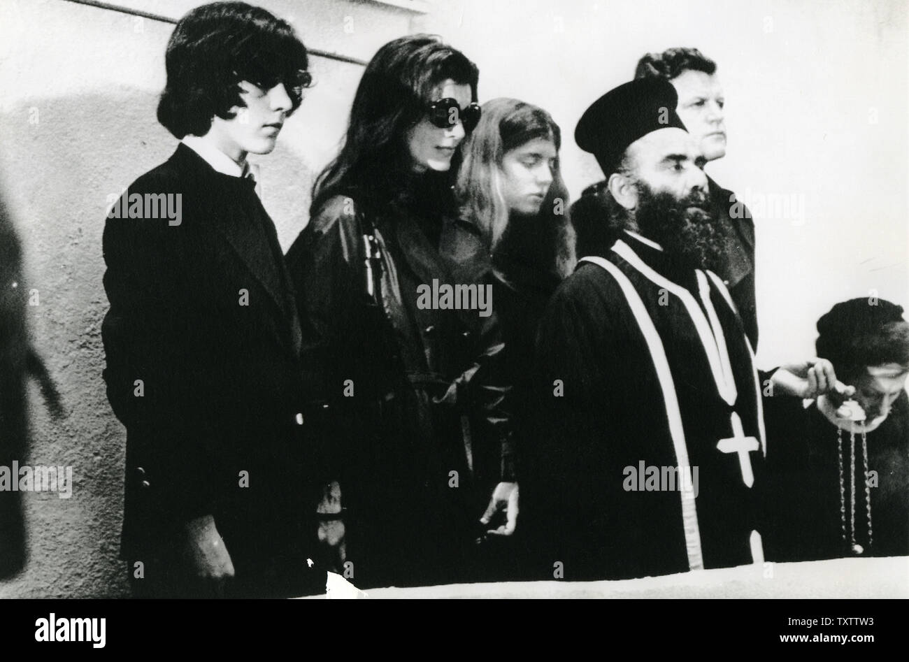 Jacqueline Kennedy Onassis (2 l), John Kennedy Jr. (L), Caroline Kennedy (C) und Senator Edward Kennedy Teilnahme an Trauerfeier für Aristoteles Onassis in Skorpios, Griechenland am 18. März 1975. Onassis starb in Paris am 15. März. UPI Stockfoto