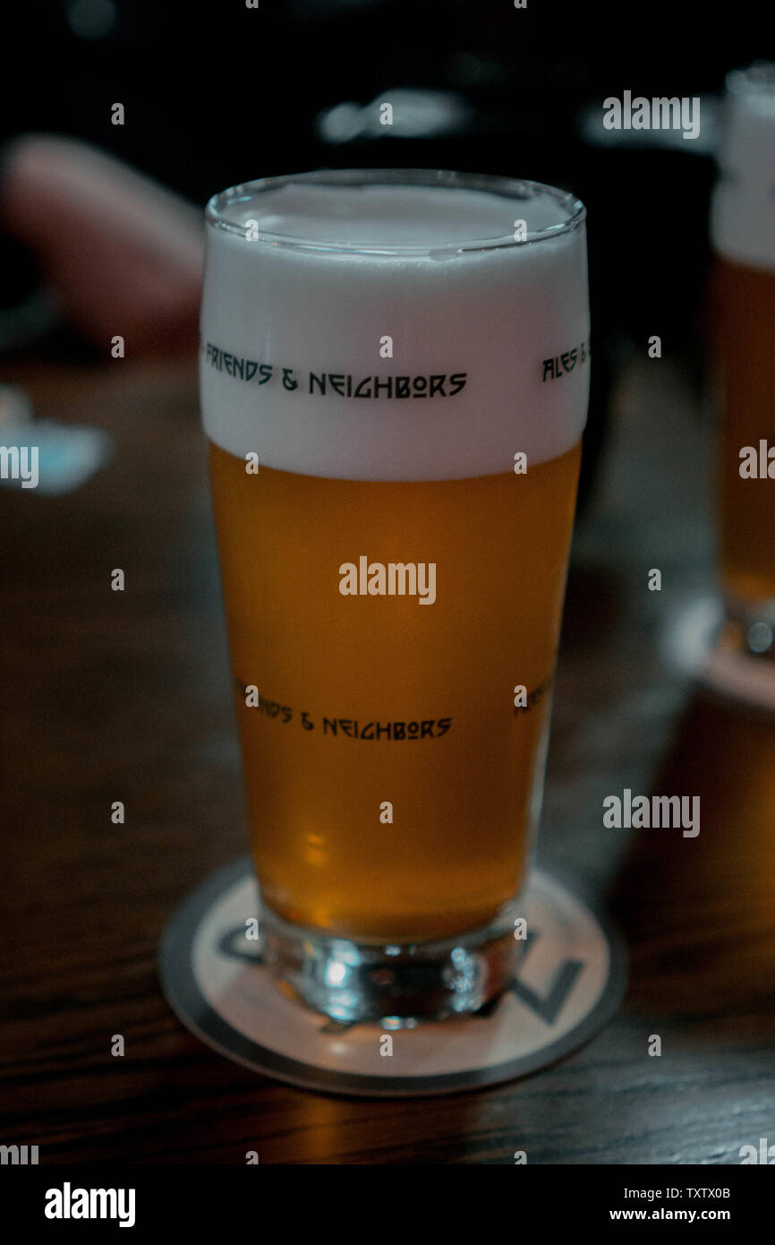 Glas Bier mit schaumigen Kopf Freunde und Nachbarn Stockfoto