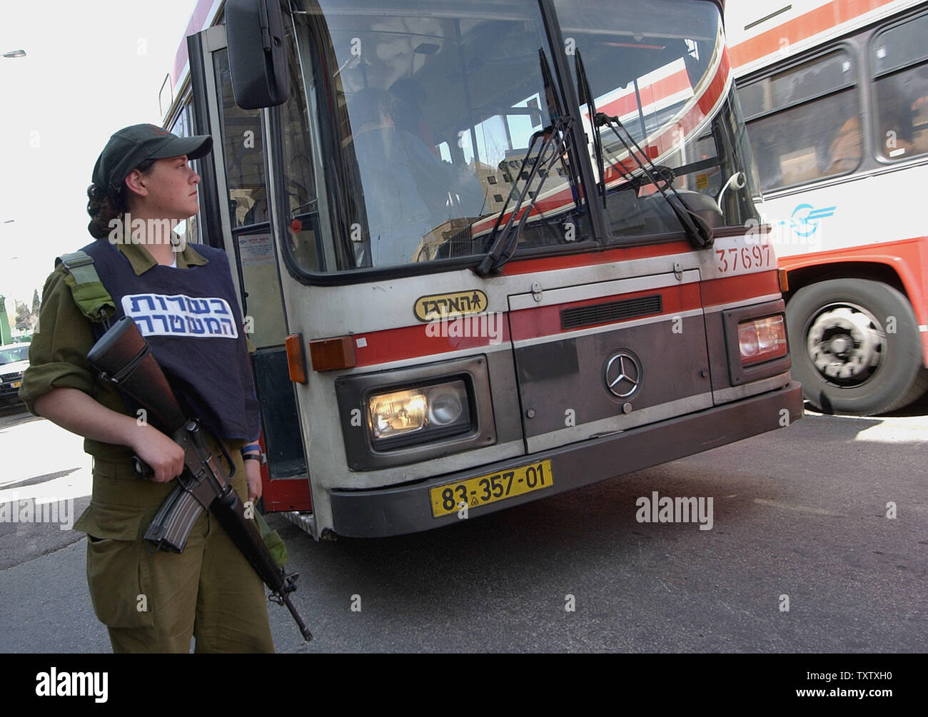 Eine israelische Grenzpolizisten bewacht eine Bushaltestelle gegen potenzielle Terroristen in zentralen Jerursalem, 24. März 2004. Israelische Armee Einheiten haben in großen Städten gebracht wurden der Polizei in einem erhöhten Alert gegen Terroranschläge seit der Tötung von Hamas Gründer und spiritueller Führer Scheich Ahmed Jassin in einem Hubschrauber Raketenangriff in Gaza Stadt. Die Hamas schwor Rache gegen alle Israelis, die für die Ermordung ihres Führers. (UPI Foto/Debbie Hill) Stockfoto