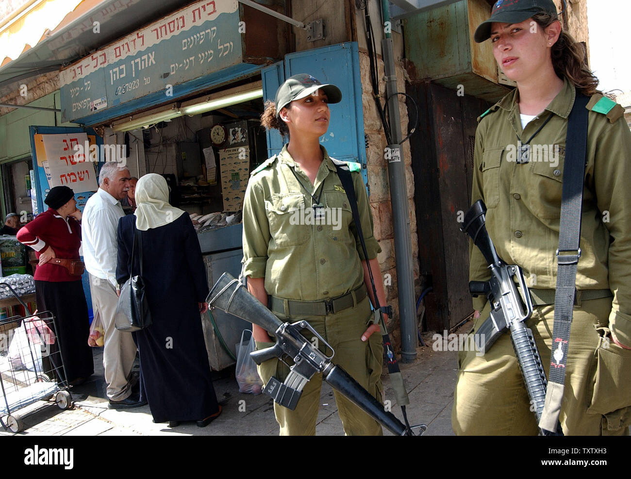 Israelische Soldaten Schutz gegen potenzielle Terroristen in der Mahane Yehuda Markt, in zentralen Jerursalem, 24. März 2004. Israelische Armee Einheiten haben in großen Städten gebracht wurden der Polizei in einem erhöhten Alert gegen Terroranschläge seit der Tötung von Hamas Gründer und spiritueller Führer Scheich Ahmed Jassin in einem Hubschrauber Raketenangriff in Gaza Stadt. Die Hamas schwor Rache gegen alle Israelis, die für die Ermordung ihres Führers. (UPI Foto/Debbie Hill) Stockfoto