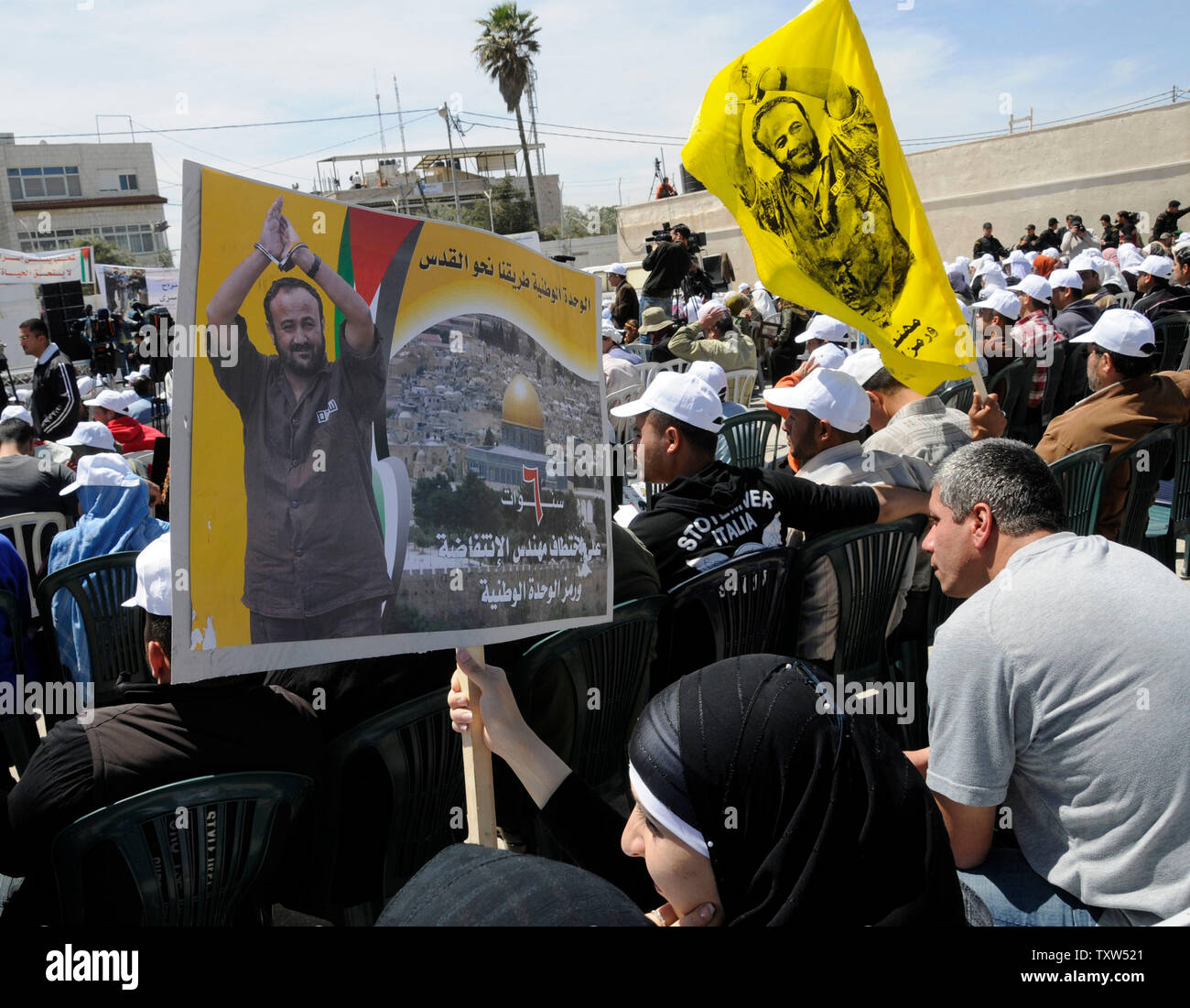 Palästinenser halten Fotos des inhaftierten palästinensischen Führers Marwan Barghouti auf palästinensische Gefangene' Day bei Präsident Mahmoud Abbas' Hauptquartier in Ramallah, West Bank, 17. April 2008. Präsident Mahmud Abbas sagt die Freilassung aller palästinensischen Gefangenen müssen Teil ein Friedensabkommen mit Israel. Mehr als 8.500 Palästinenser in israelischen Gefängnissen festgehalten. (UPI Foto/Debbie Hill) Stockfoto