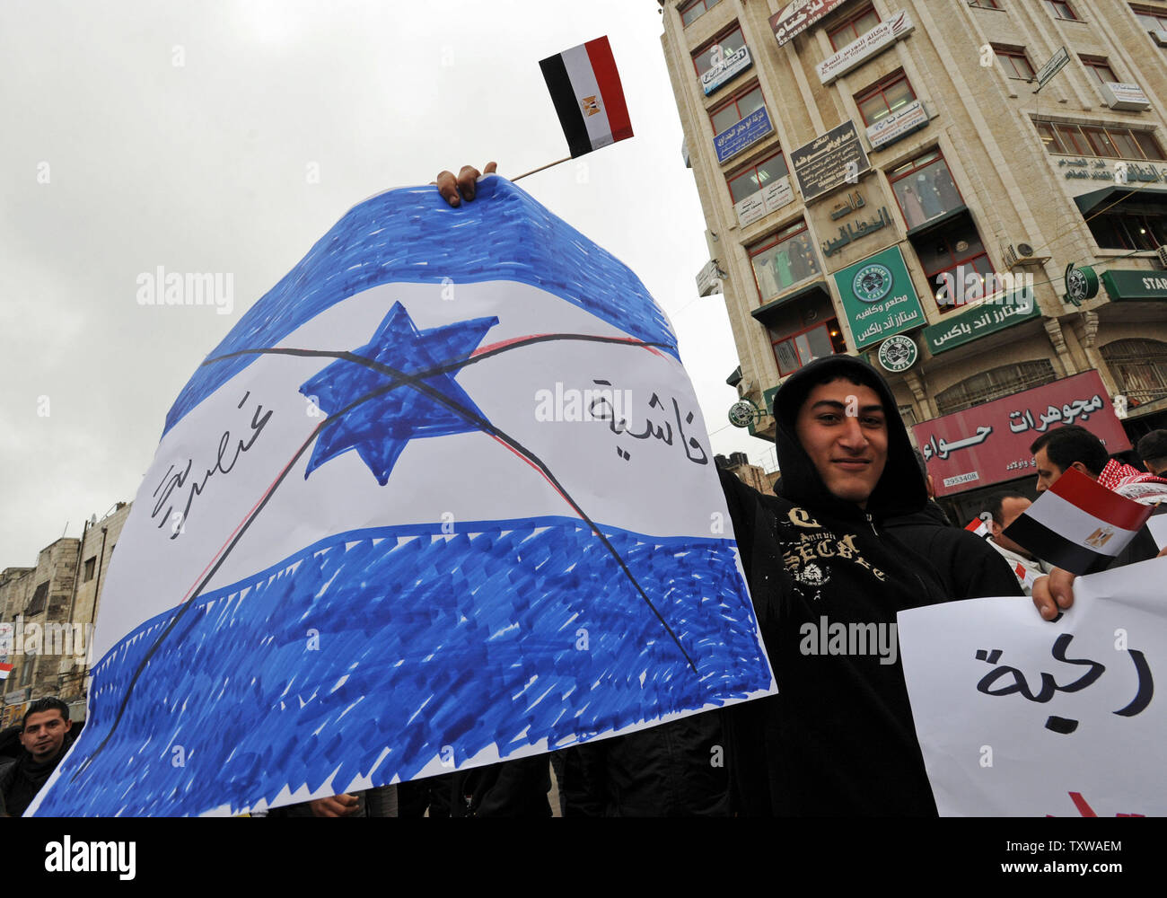 Einen palästinensischen Demonstrant hält und anti-Israel Poster und eine Mini-ägyptischen Flagge bei einer Demonstration in Ramallah, West Bank, Solidarität mit den Ägyptischen regierungsfeindlichen Demonstranten zu zeigen, 5. Februar 2011. Die palästinensische Demonstranten für globale Demokratie und dem Ende der autoritären Regierungen. UPI/Debbie Hill Stockfoto