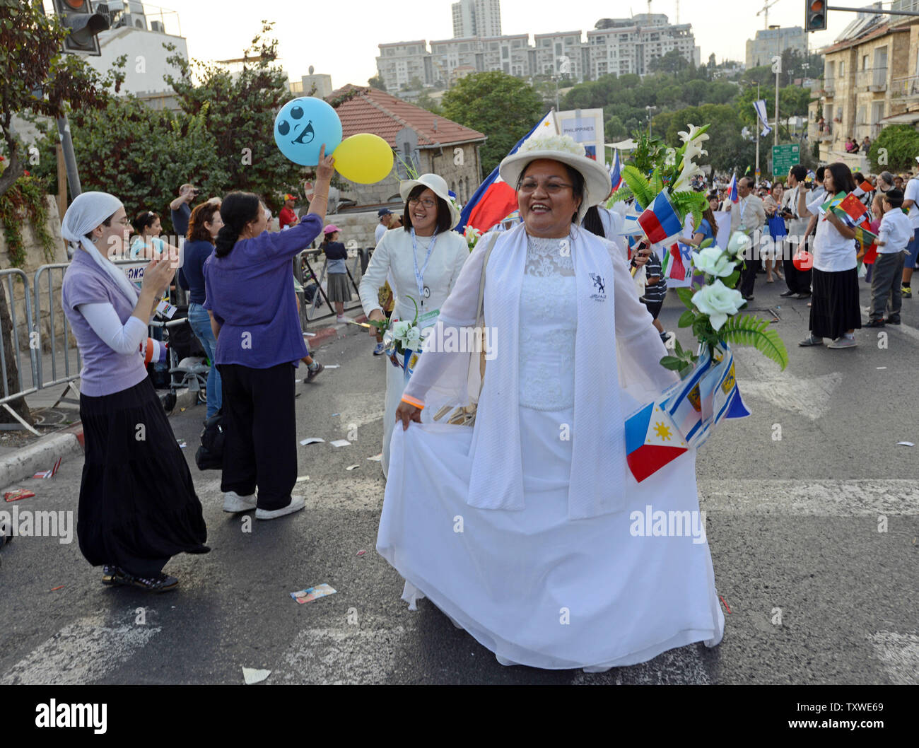 Israelis wave Pro-Israel Christen aus den Philippinen, wie sie in der jährlichen Jerusalem Parade während der Sukkot Urlaub, oder Fest der Tablernacles, im Zentrum von Jerusalem, Israel, 4. Oktober 2012. Mehr als 5.000 Christen aus über 100 Ländern strömten nach Jerusalem, am Fest der Laubhütten Urlaub ihre Unterstützung für Israel und das jüdische Volk, an einer Veranstaltung der Internationalen Christlichen Botschaft in Jerusalem gefördert zu zeigen. UPI/Debbie Hill Stockfoto