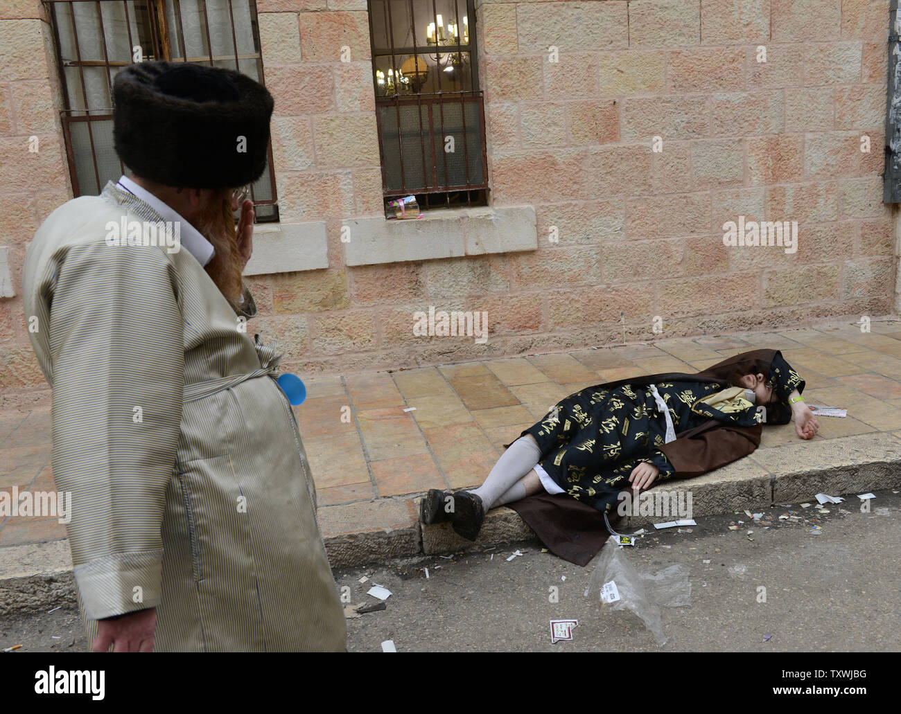 Ein betrunkener ultra-orthodoxe Juden auf der Straße während des Festes von Purim in Mea Shearim in Jerusalem, Israel, 17. März 2014 bestanden. Die purim Urlaub erinnert an die Befreiung des jüdischen Volkes von Völkermord im alten Persien, wie sie im Buch Esther erzählt. UPI/Debbie Hügel. Stockfoto