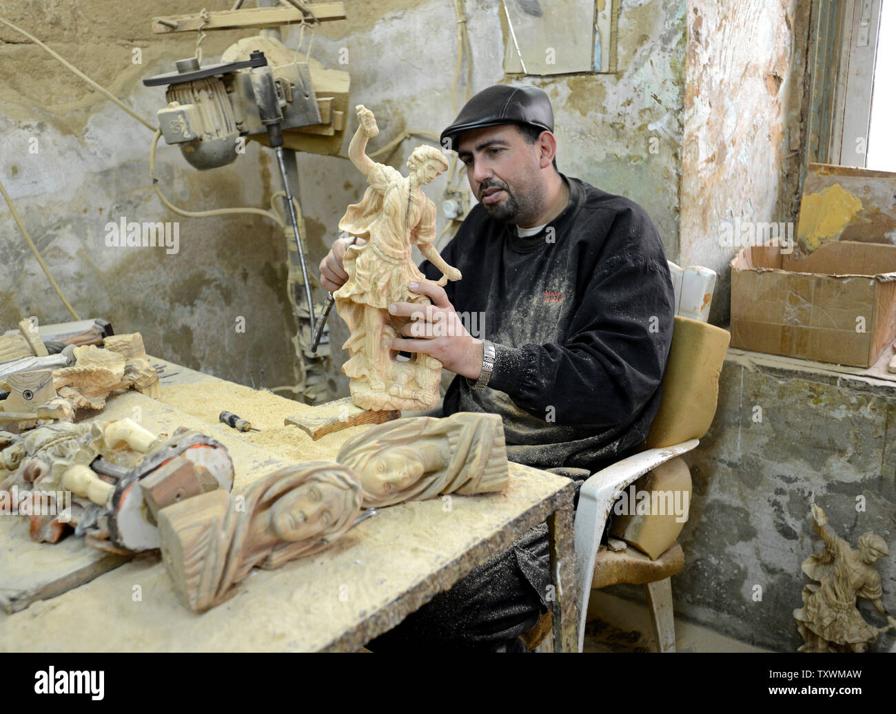 Eine palästinensische Handwerker schnitzt ein olivenholz Statue eines Engels in einer Werkstatt in Beit Sahour, in der Nähe von Bethlehem, West Bank, 18. Dezember 2014. Das Heilige Land Handwerk Genossenschaft bietet Arbeitsplätze für Palästinenser in den Bethlehem Bereich Handwerk Souvenirs für die Touristen. UPI/Debbie Hill Stockfoto