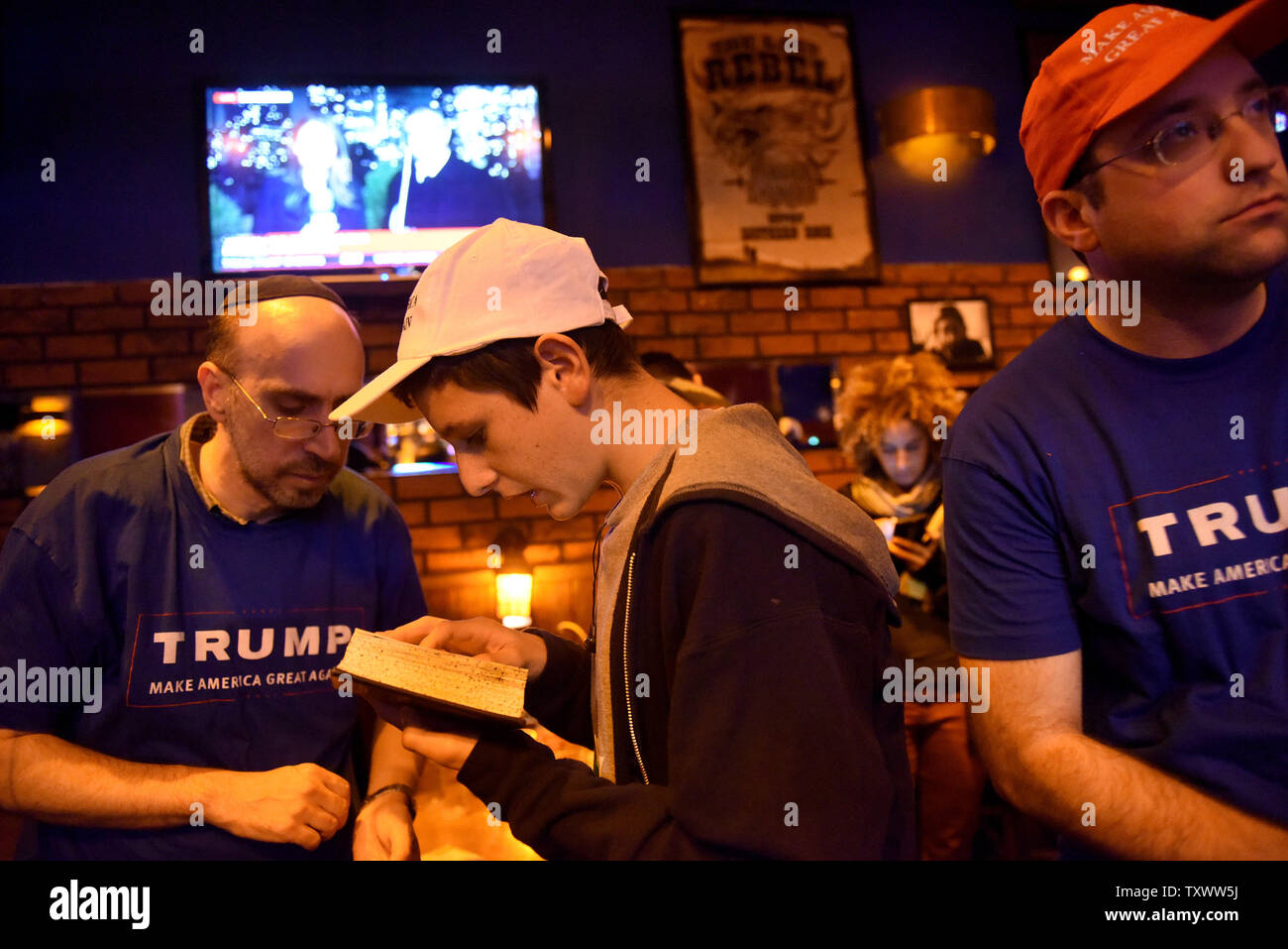 Trump Anhänger beten, während sie live Updates der US-Präsidentschaftswahlen Ergebnisse in Mike's Place Bar im Zentrum von Jerusalem, Israel, November 9, 2016. Foto von Debbie Hill/UPI Stockfoto