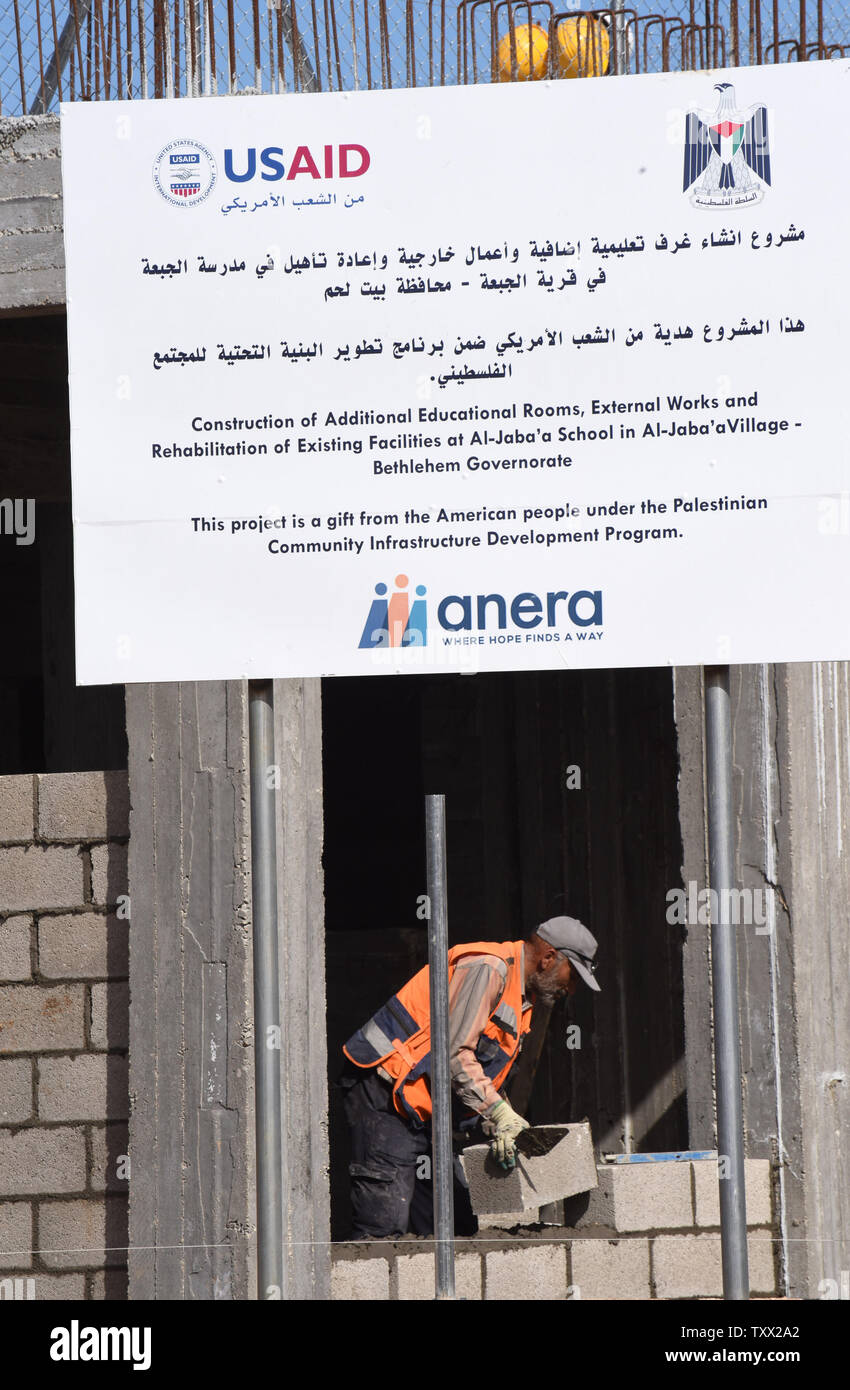 Ein palästinensischer Bauarbeiter nimmt ein Baustein bei der Sanierung und Erweiterung der Schule des Mädchens in Al-Jabba, in der Nähe von Bethlehem, West Bank, die von der USAid, US-Behörde für Internationale Entwicklung, 23. Januar 2019 finanziert wird. Die $ 1,4 Millionen Dollar Projekt wird Ende Januar beendet werden, da die Verwaltung der US-Präsident Donald Trump Stop wird der Finanzierung palästinensischer Projekte und auch wegen dem palästinensischen Ministerpräsidenten Rami Hamdallah erklärt hat, dass die Palästinensische Autonomiebehörde nicht mehr akzeptieren Finanzierung aus Amerika. Die Schule wird unbrauchbar zu werden. Stockfoto