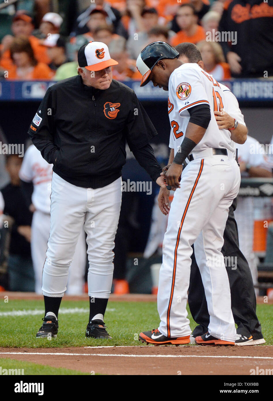 Baltimore Orioles Manager Buck Showalter (L) prüft auf Alejandro De Aza nach De Aza von einem Pitch im ersten Inning von Spiel 1 der American League Division Series gegen die Detroit Tigers auf Orioles Park geschlagen wurde in Camden Yards, Baltimore, Maryland am 2. Oktober 2014. UPI/Kevin Dietsch Stockfoto